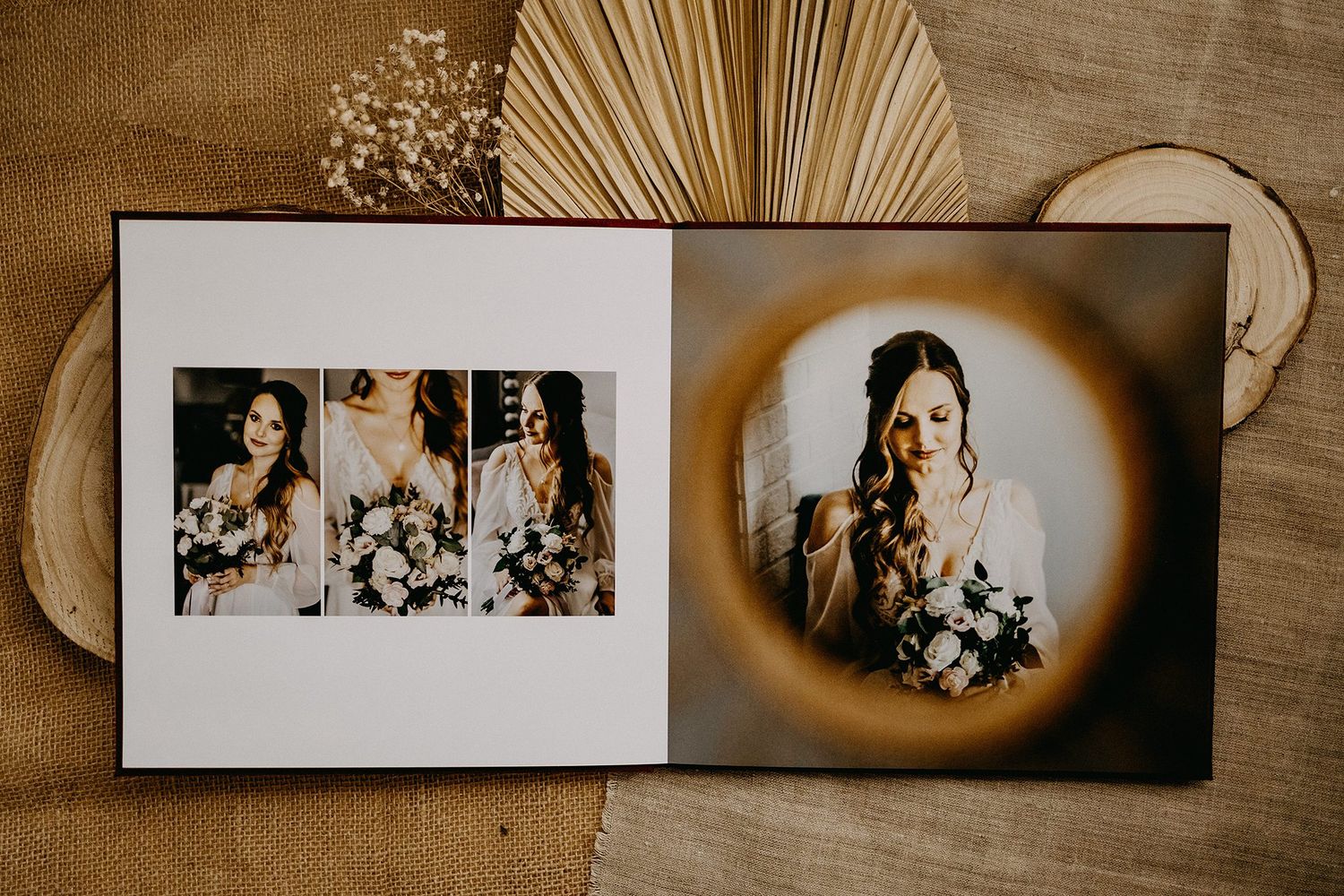 Open wedding photo album showing bride with bouquet portraits against dark background with dried palm leaf decor.