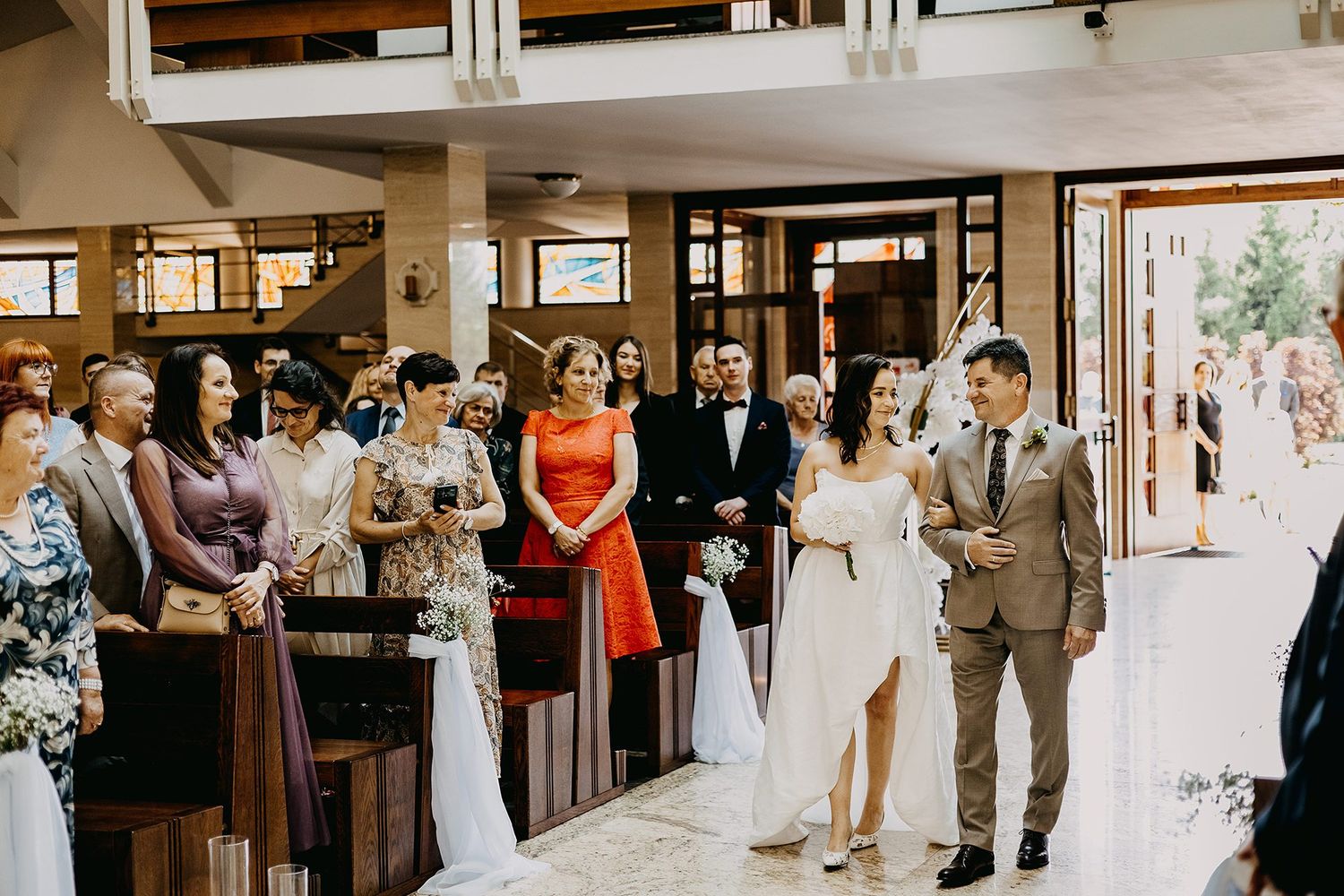 Bride and groom walking down the aisle at an elegant church wedding ceremony.
