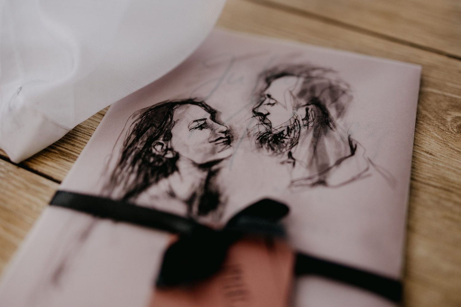 Romantic pencil sketch portrait of a couple face-to-face tied with a black ribbon.