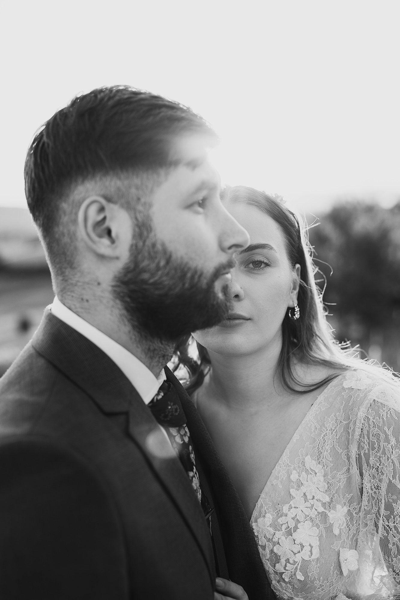 Black and white portrait of a bearded groom and bride in an intimate close moment.