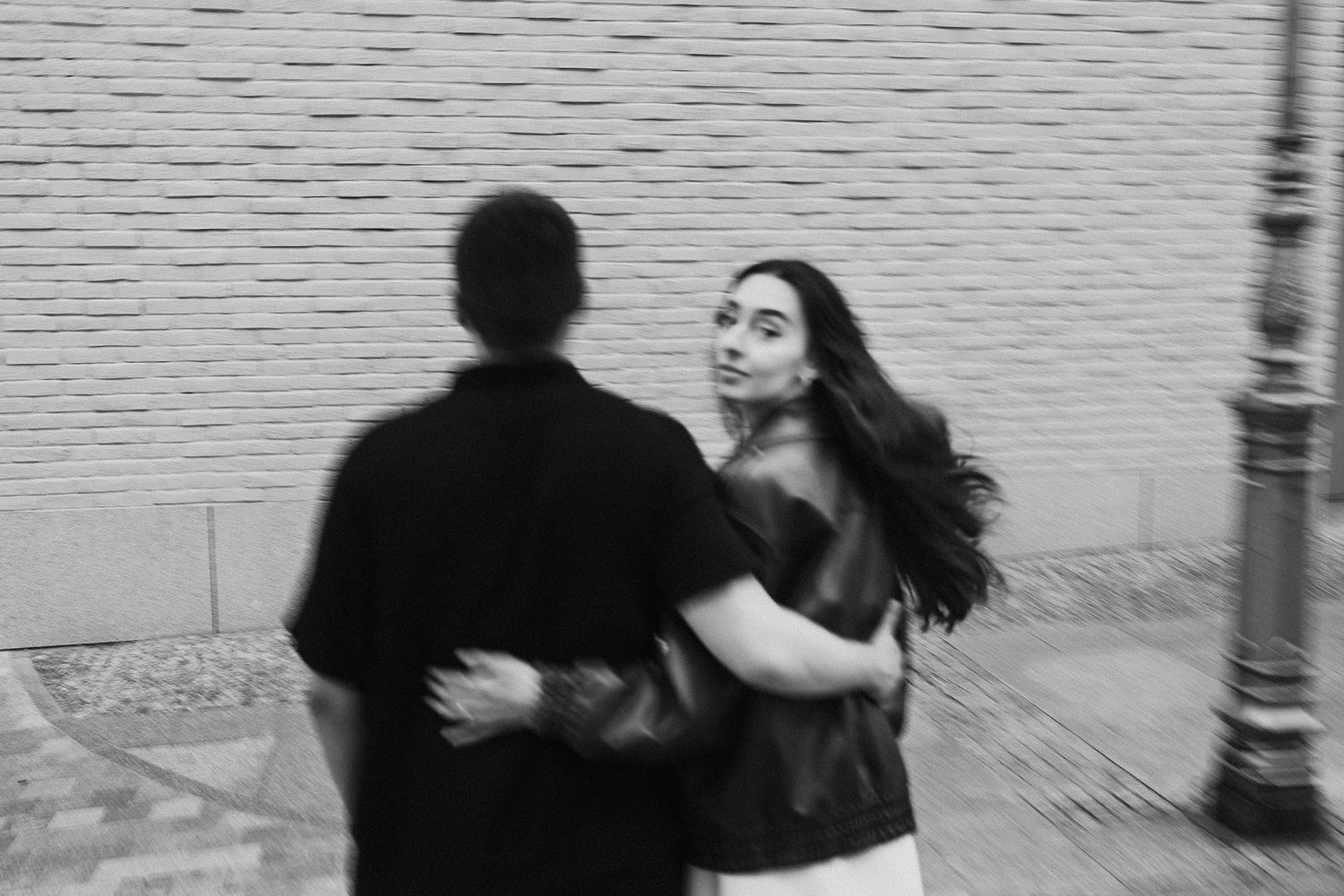 Black and white photo of a couple dancing and embracing on a city street.