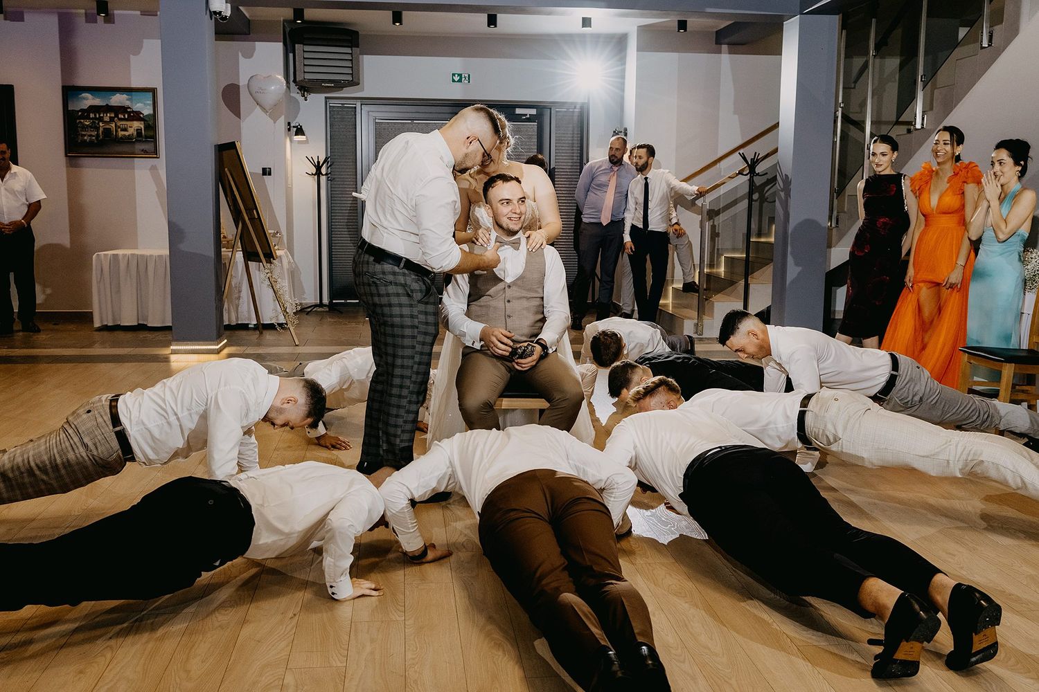 Fun wedding reception dance floor moment with guests performing playful group activity together.