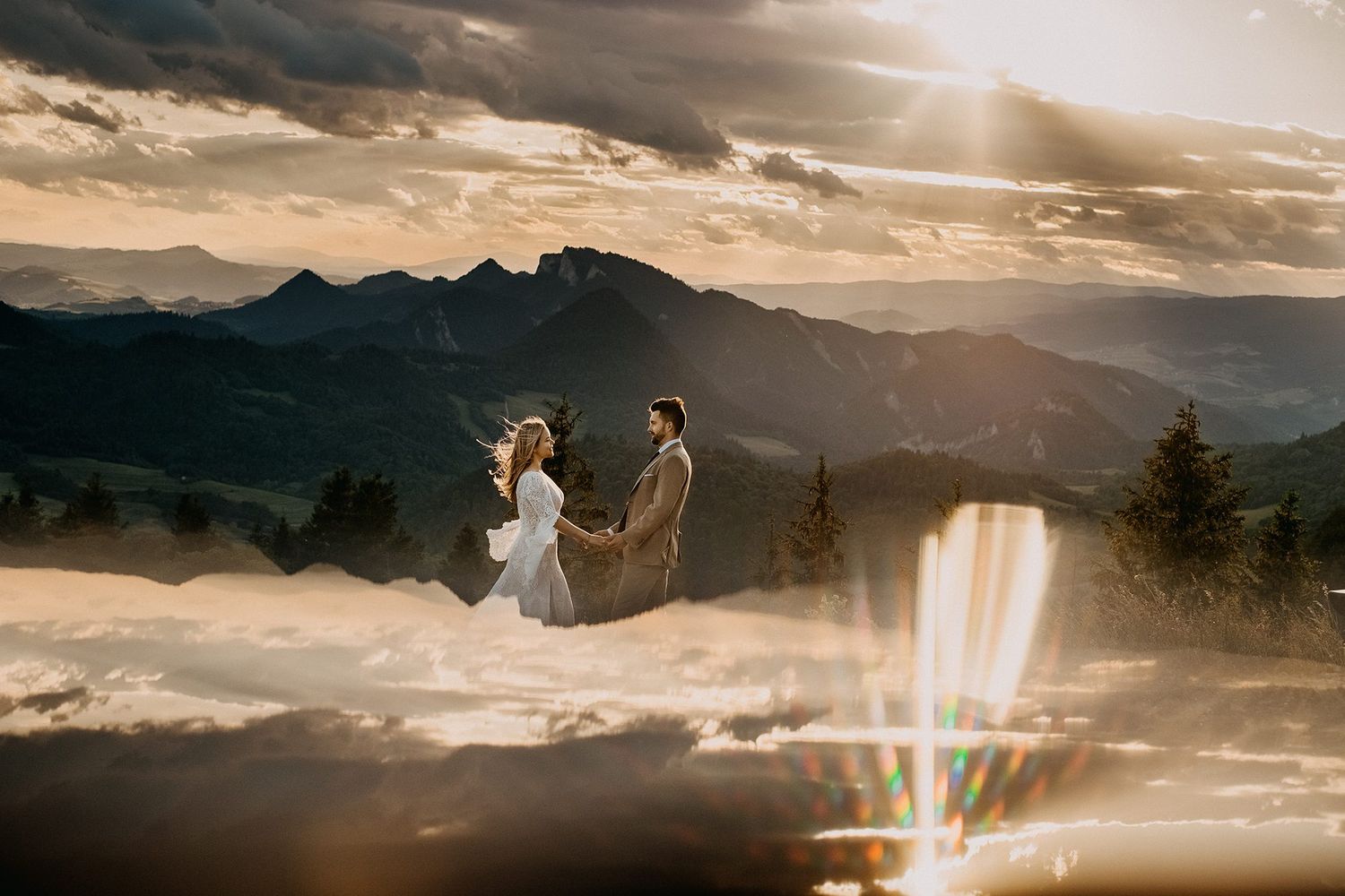 Romantic couple holding hands at golden sunset with dramatic mountain landscape backdrop.