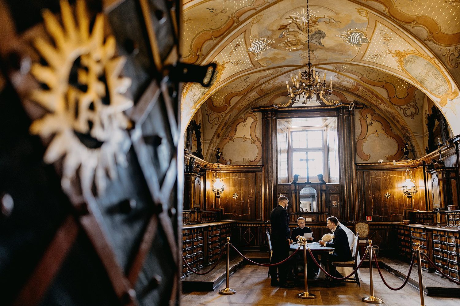 Couple signing wedding documents in an ornate baroque-style room with vaulted painted ceilings.