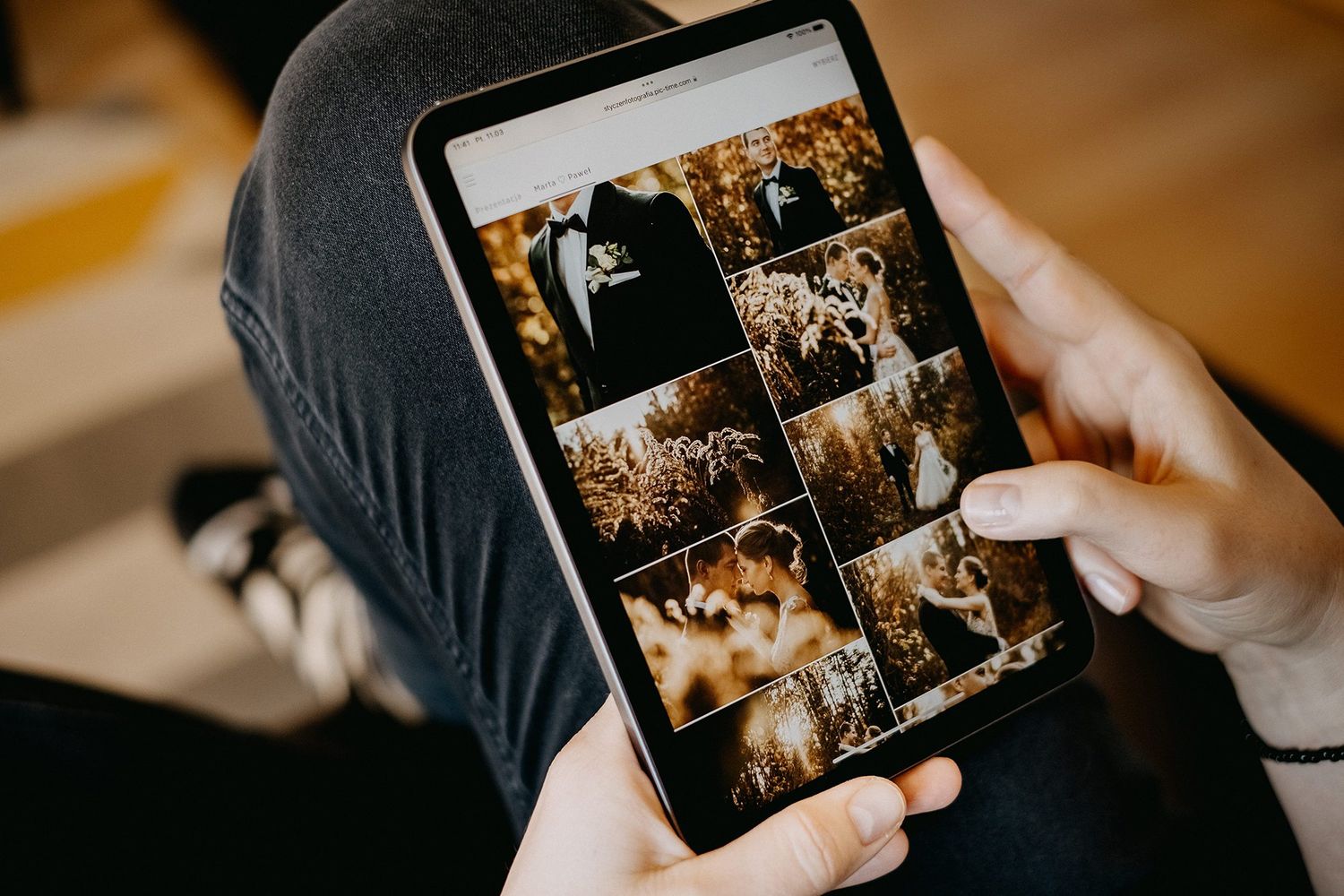 Person browsing a wedding photo gallery grid on a tablet with warm toned images.