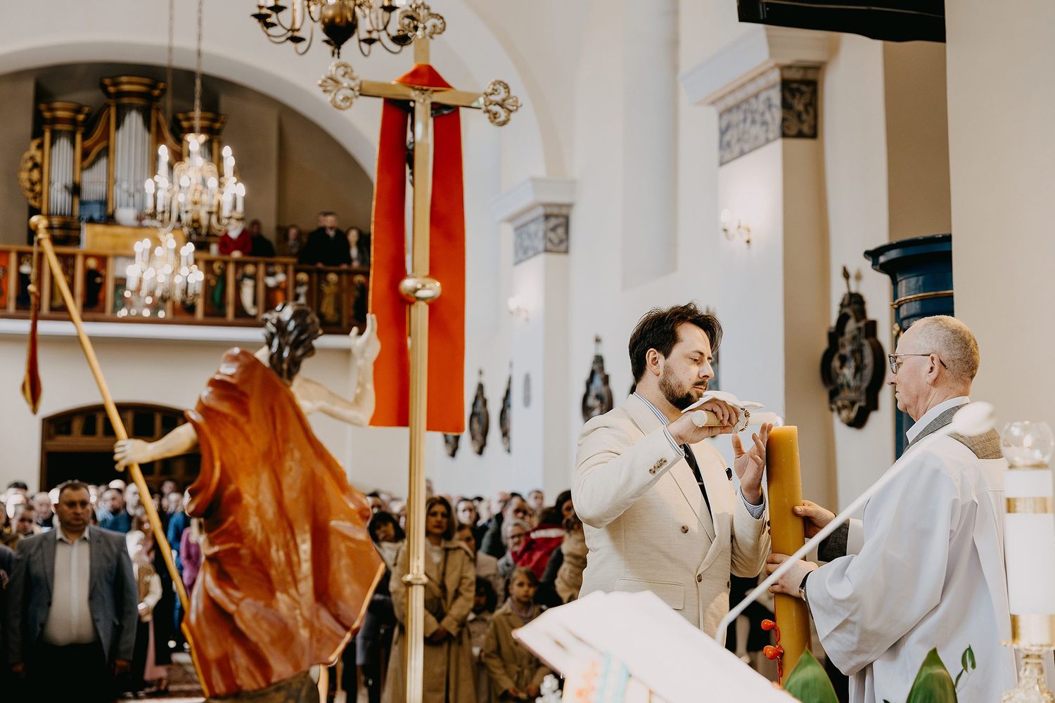 A man plays a horn instrument during a formal church ceremony with clergy present.