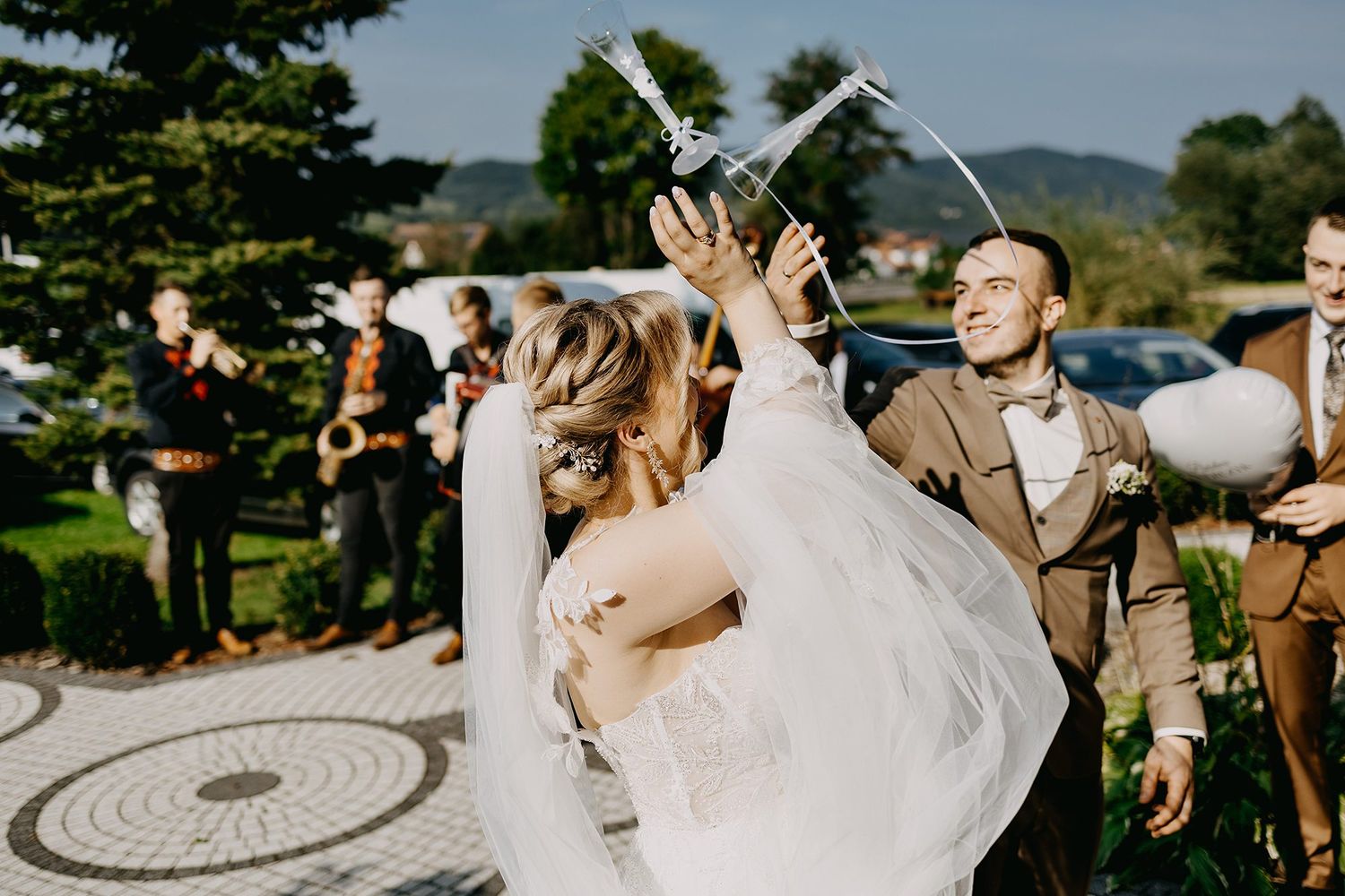 Bride and groom releasing white dove during outdoor wedding ceremony with guests watching.