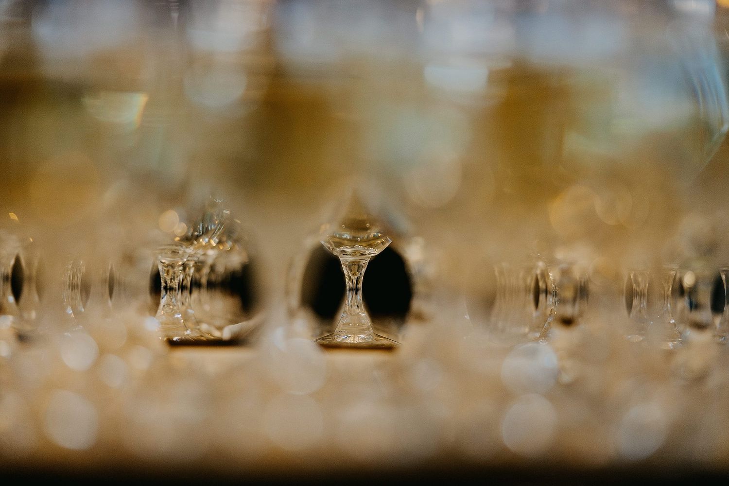 Close-up of elegant crystal champagne glasses arranged for a wedding reception celebration.