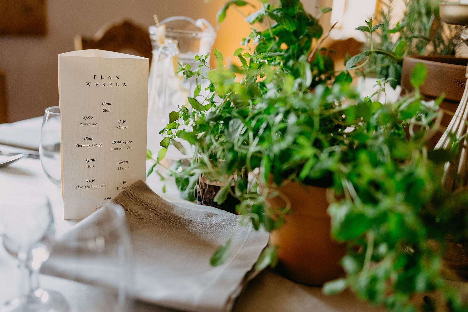 Wedding table setting with herb centerpiece and elegant menu card.