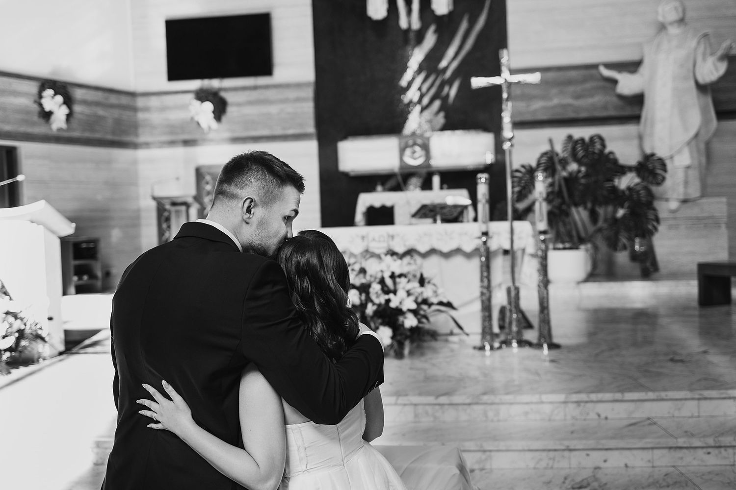 Bride and groom share an intimate embrace at the altar during their church wedding ceremony.