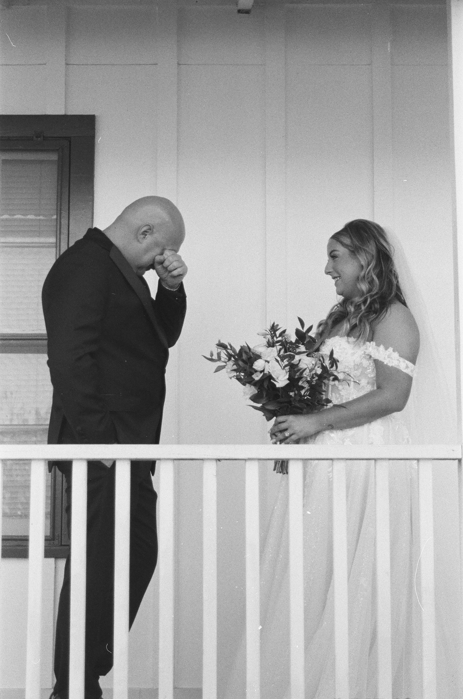 Emotional groom wipes tears seeing his bride for the first time on their wedding day first look.