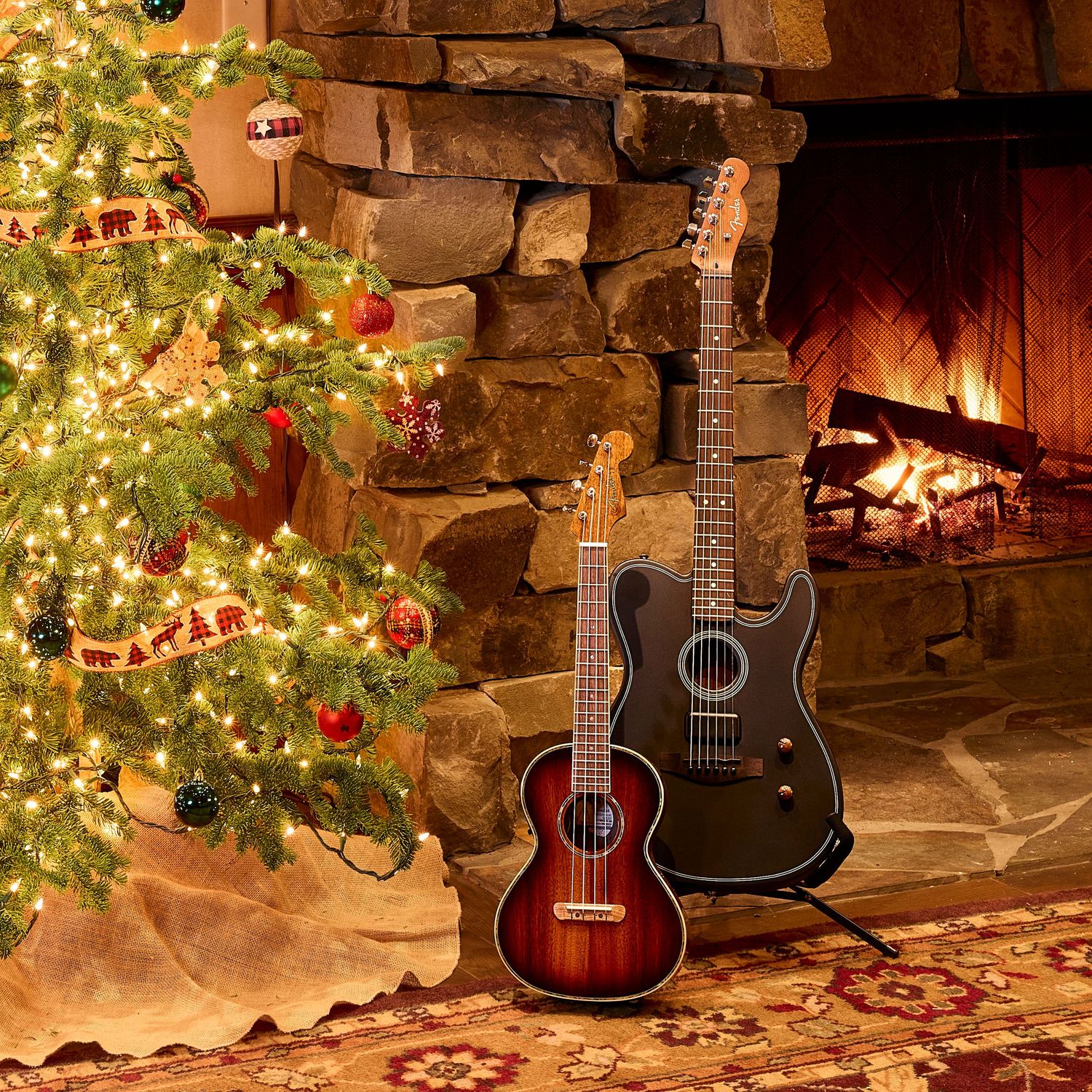 Two guitars lean against a stone fireplace beside a decorated Christmas tree in a cozy holiday setting.