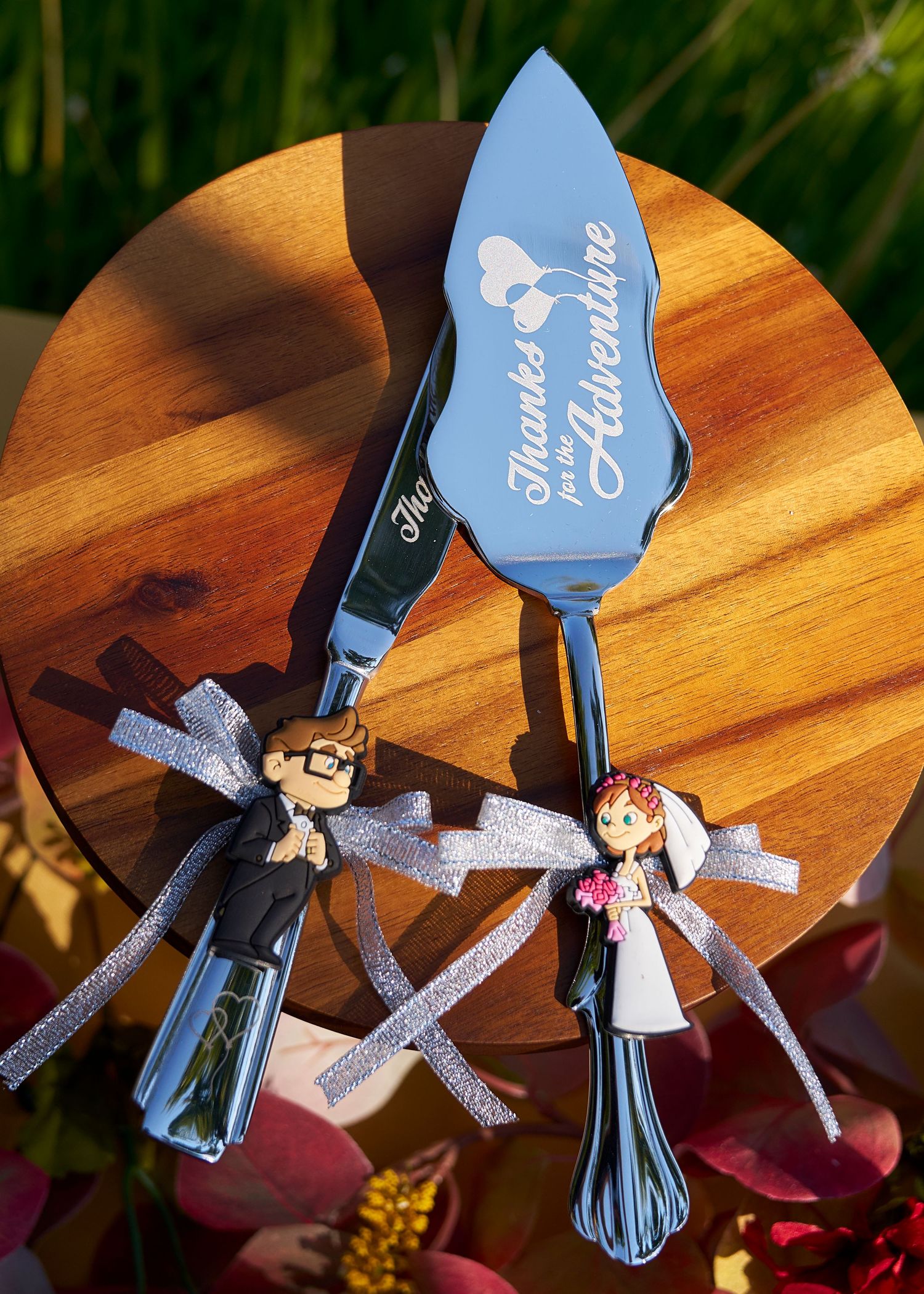 Personalized wedding cake serving set engraved with Thanks for the Adventure featuring Up movie character figurines with ribbon bows.