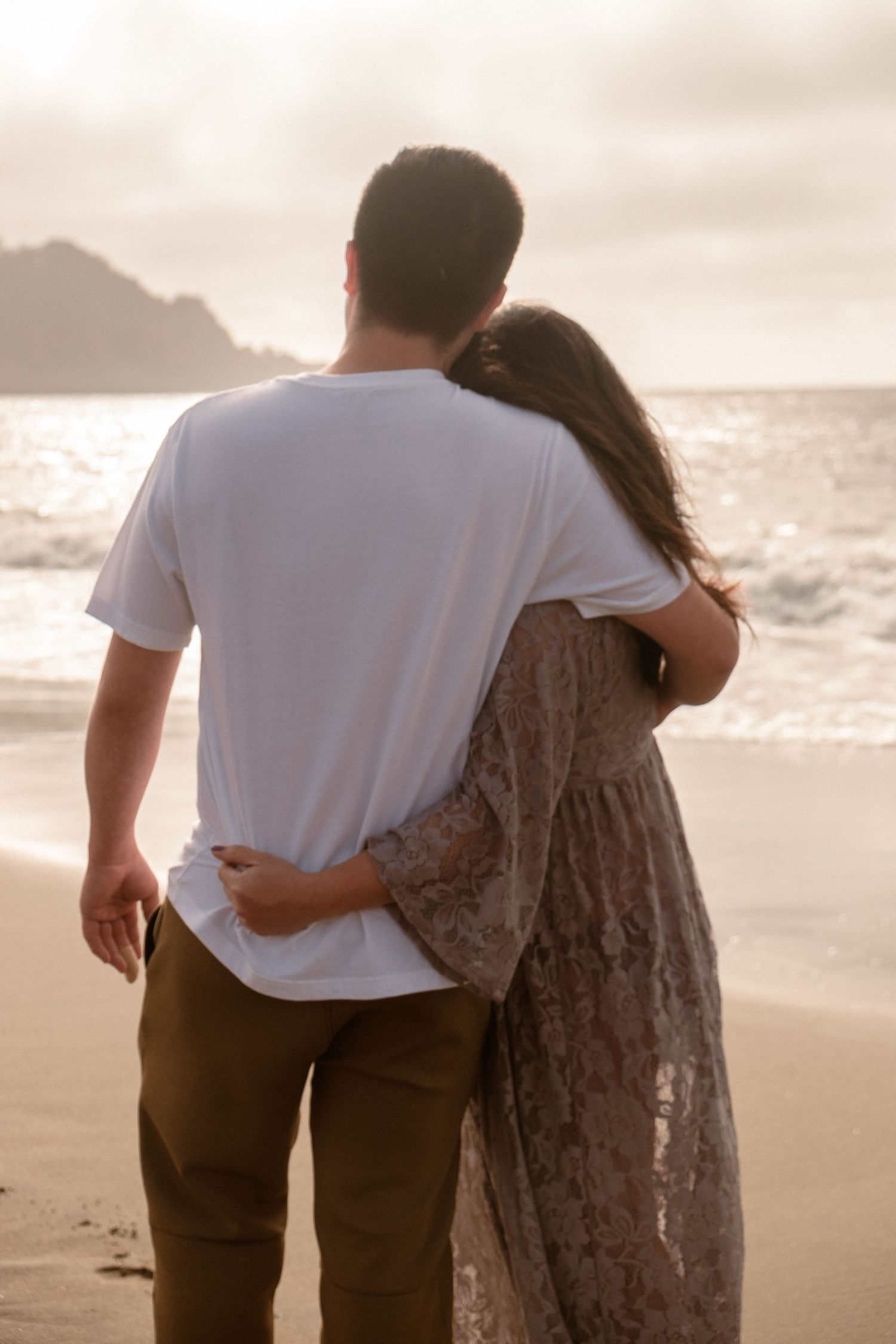 Maternity photography session at Baker Beach featuring a couple with looking out at the beach