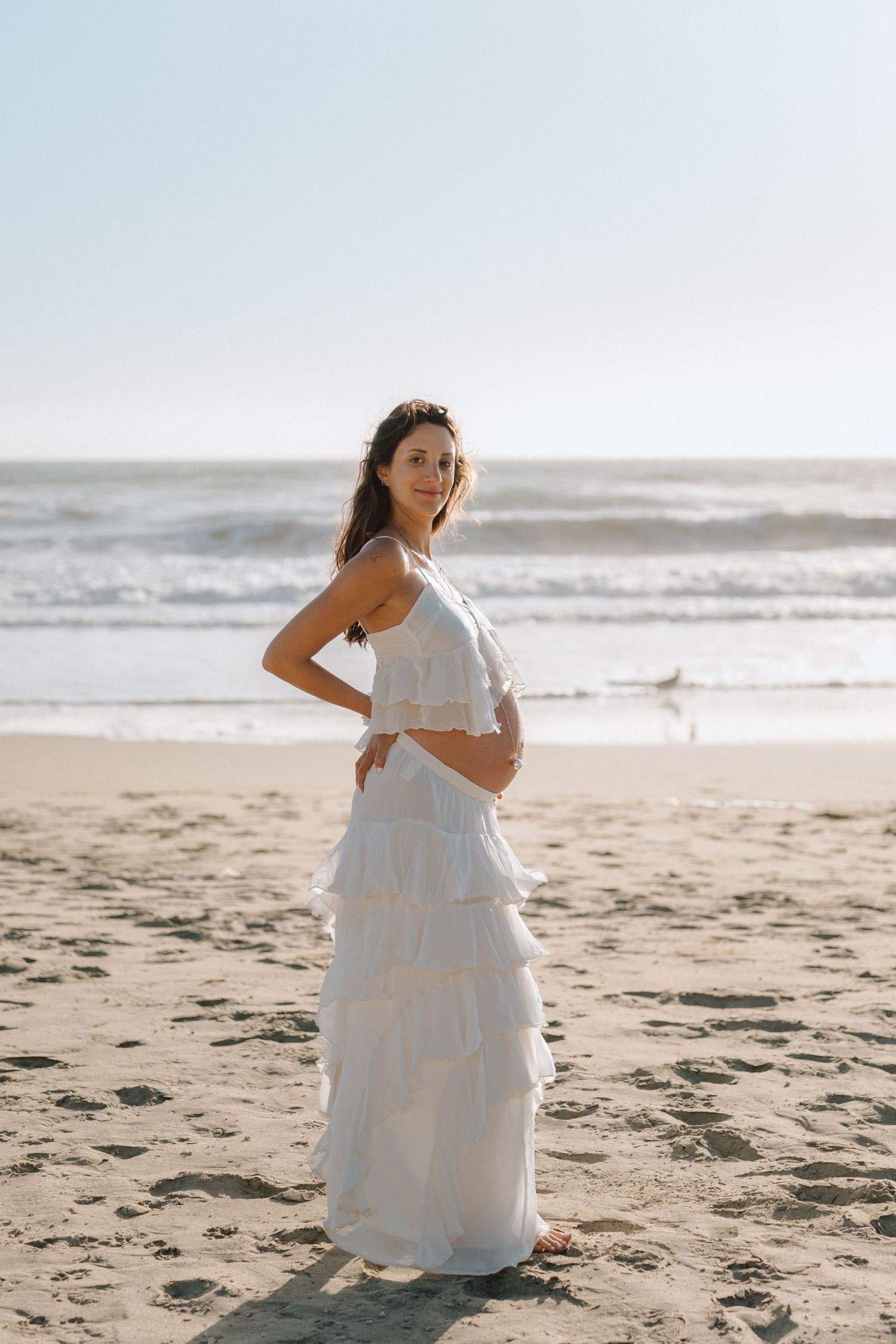mom holding her baby bump at the bay area beach maternity session in Daly City