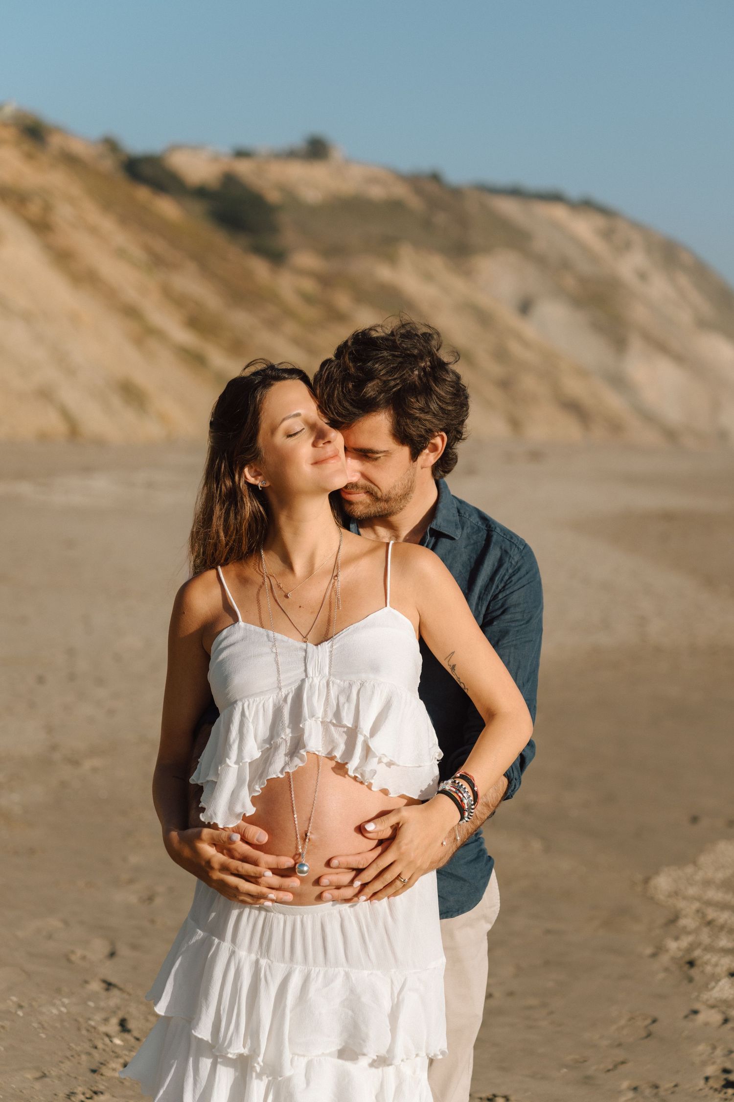 parents to be embracing each other during golden hour maternity photo session in Daly City