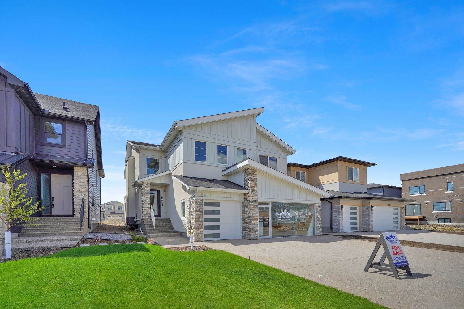 New two-story suburban home with board and batten exterior, stone facade, and concrete driveway.