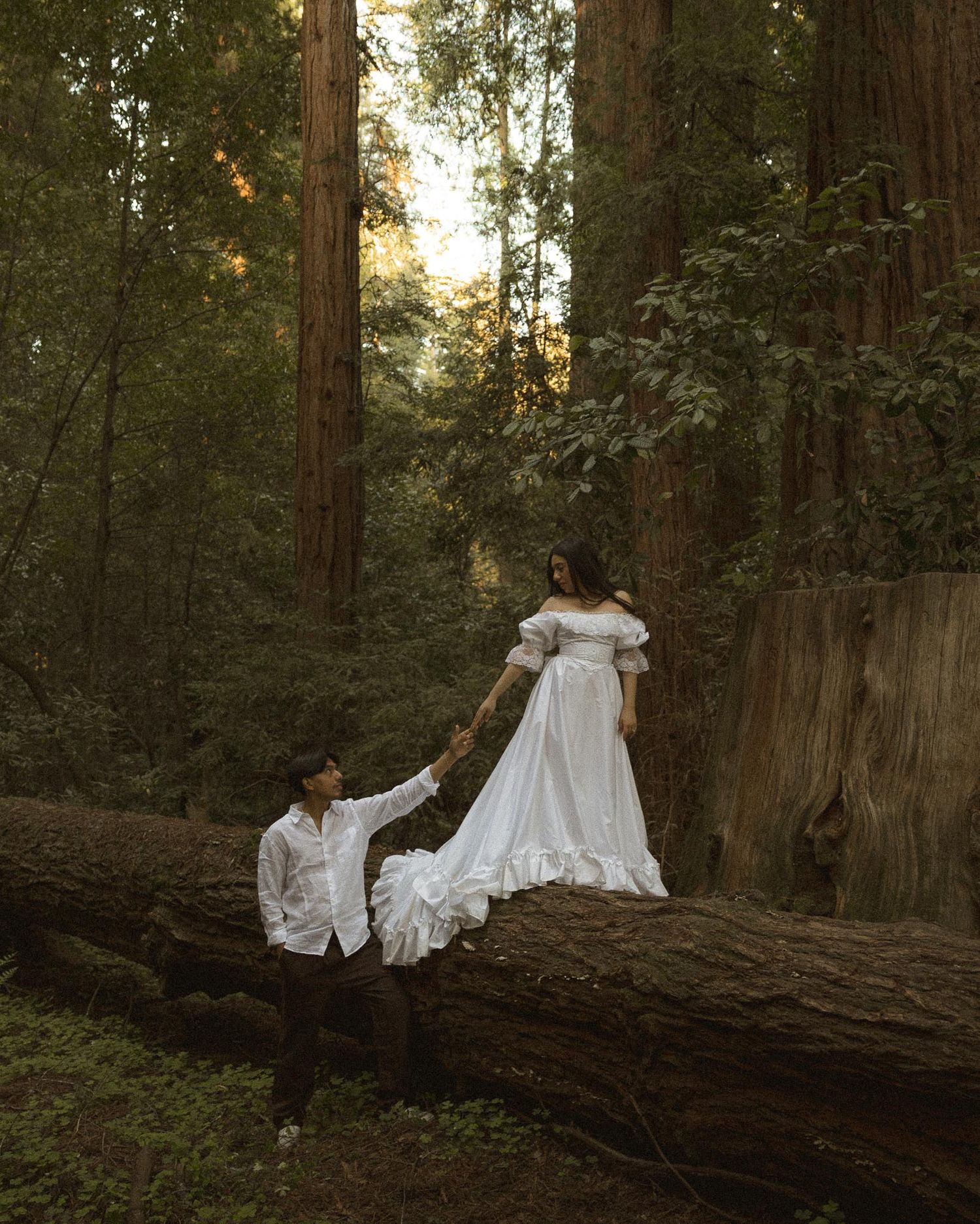 Elegant bride walking through a California redwood forest during an intimate wedding photography session.