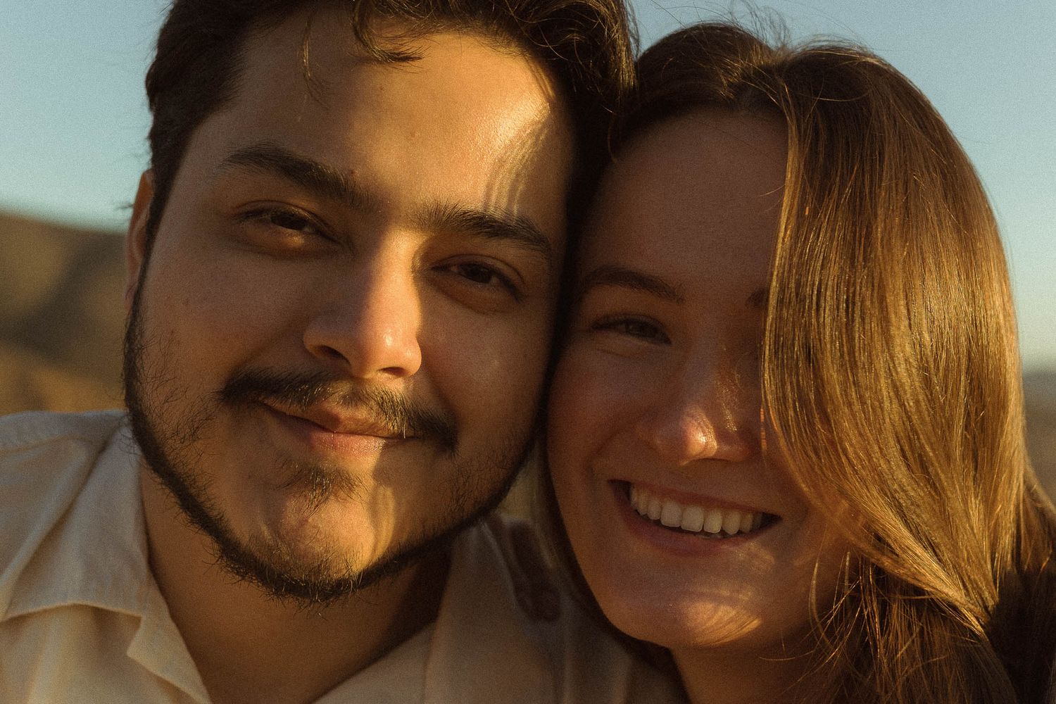 Happy couple smiling during a golden hour engagement photoshoot in the San Francisco Bay Area.