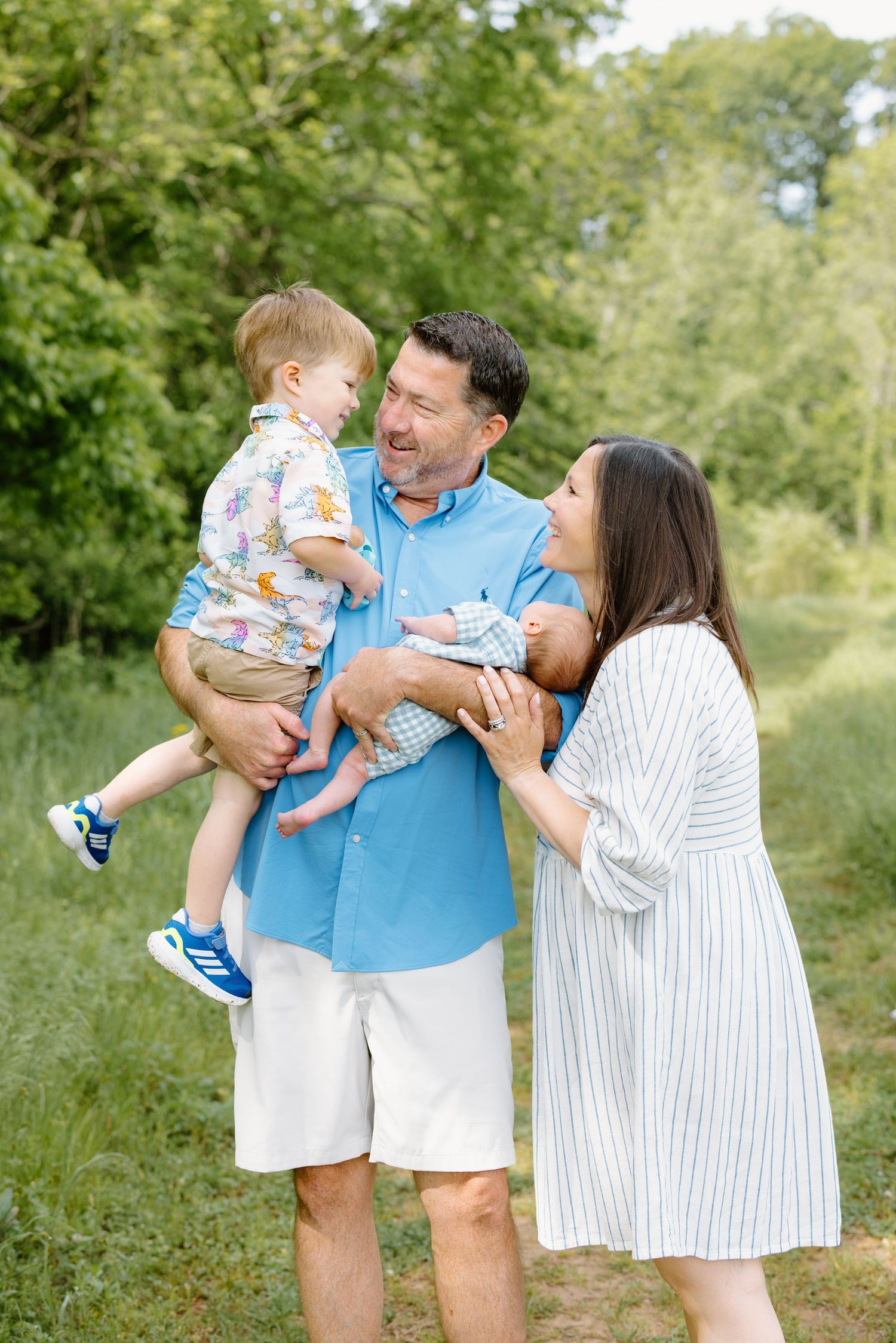 Happy family spending time together outdoors in a park-like setting on a sunny summer day.