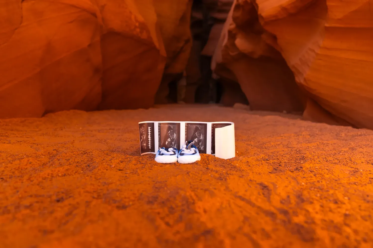 Pregnancy announcement photos inside Antelope Canyon, Arizona featuring desert sandstone and natural light.