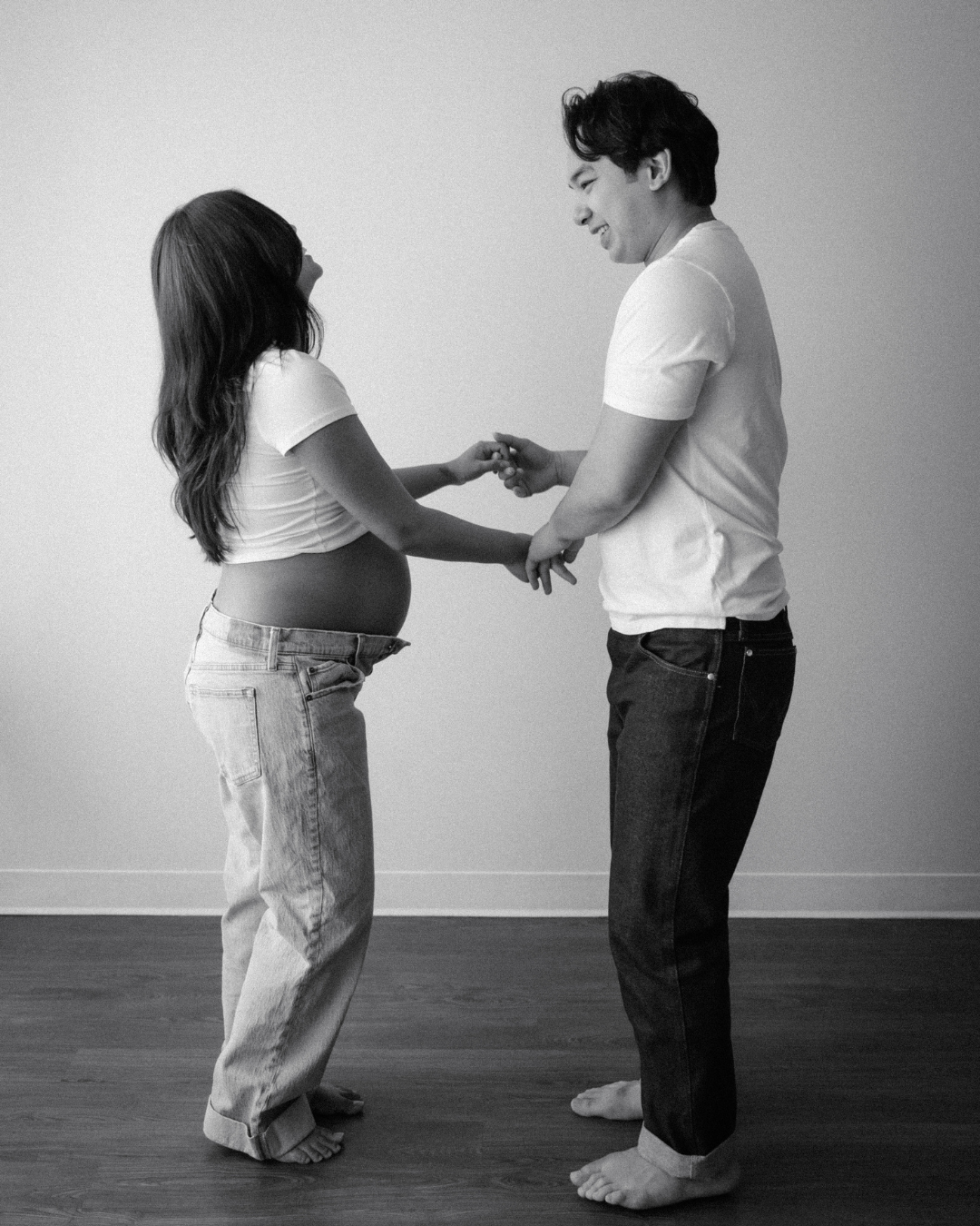 Black and white photo series showing a father and mother to be interacting and moving in a minimalist interior space.
