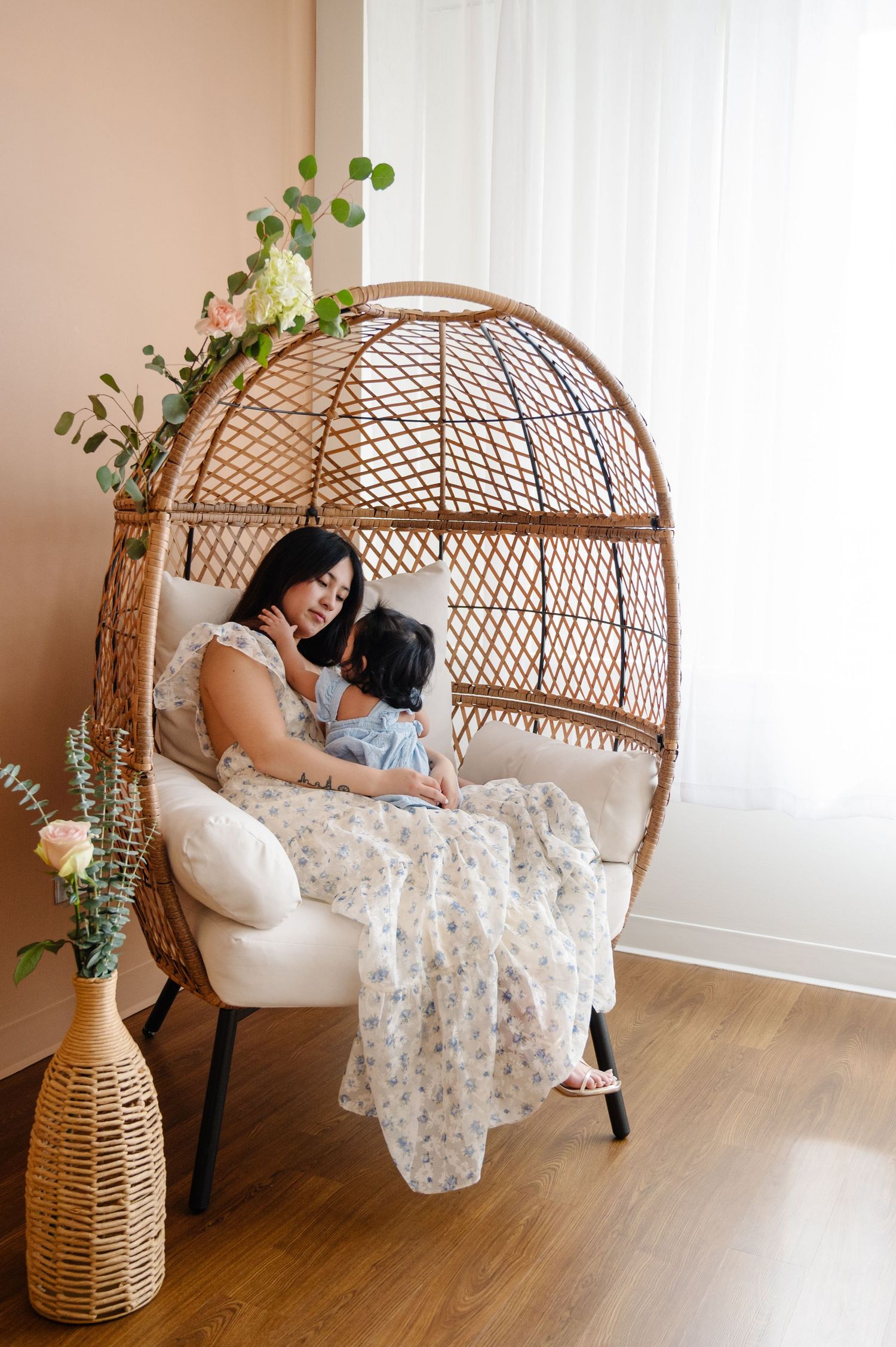 A peaceful indoor scene with natural light streaming through white curtains and rattan furniture.