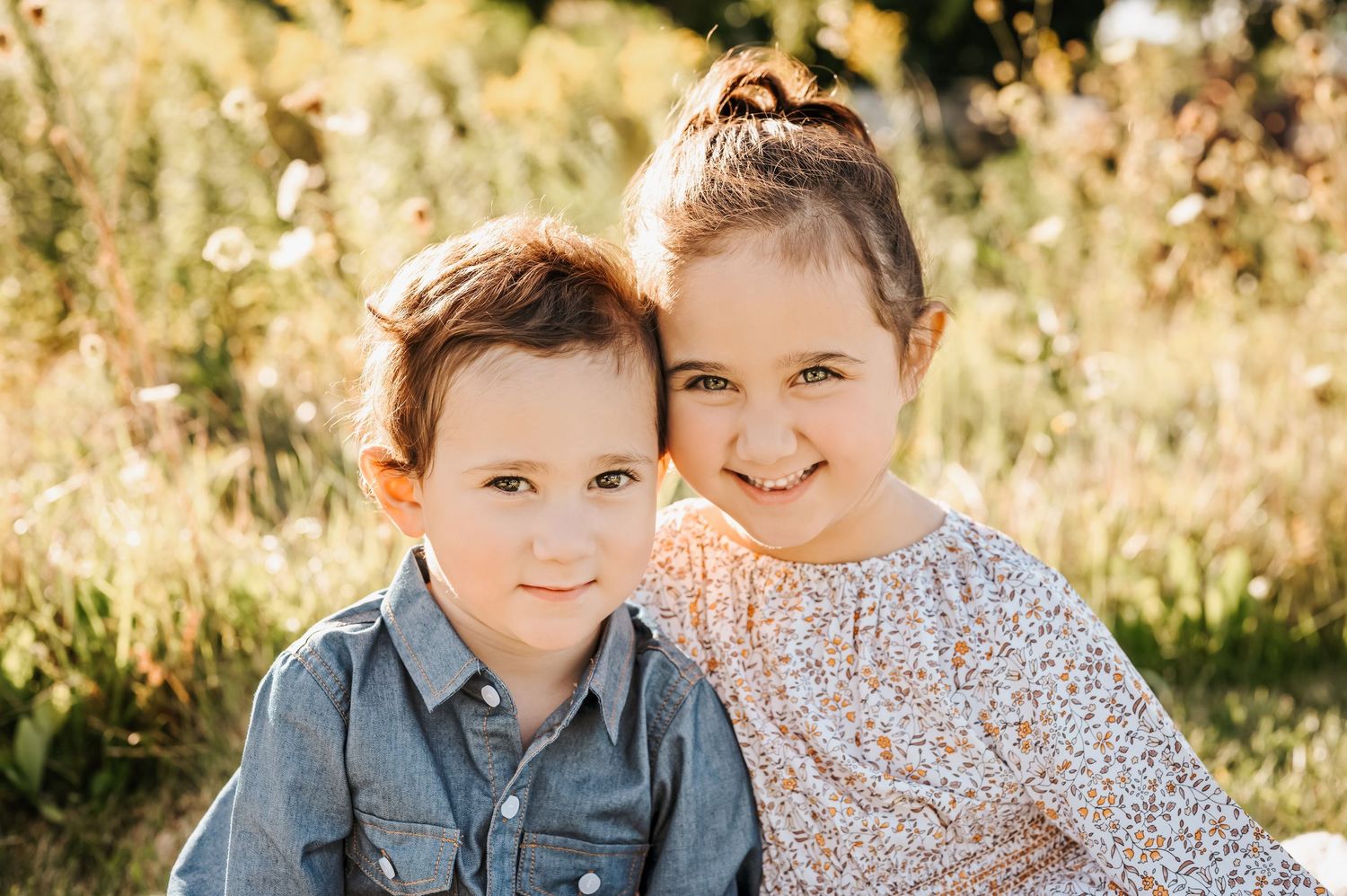 Outdoor family portrait session in golden field during sunset with soft natural lighting.