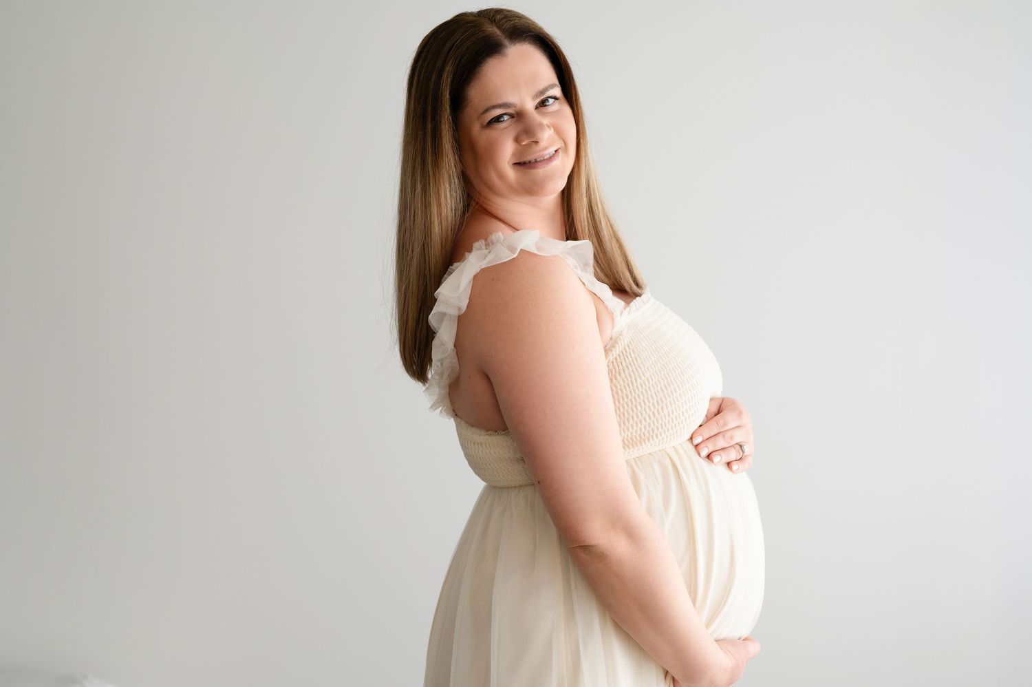 A person in a sleeveless white dress poses against a light background in a series of elegant portrait shots.