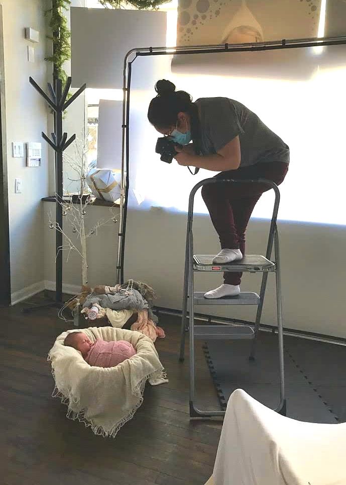 Behind the scenes photo of Crystal photographing a newborn.