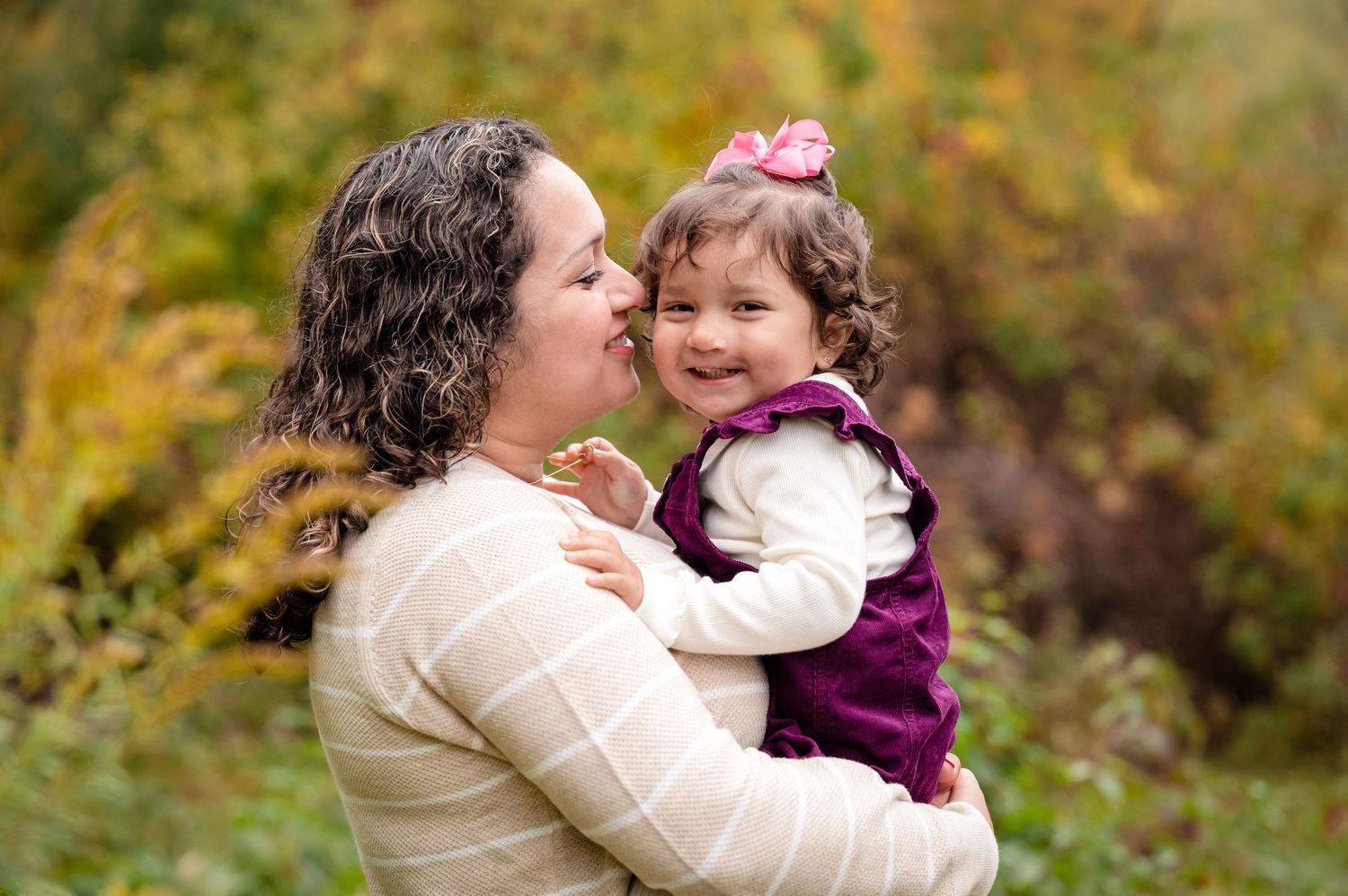 A mother and daughter share giggles during this tender moment at a local forest preserve with fall foliage.