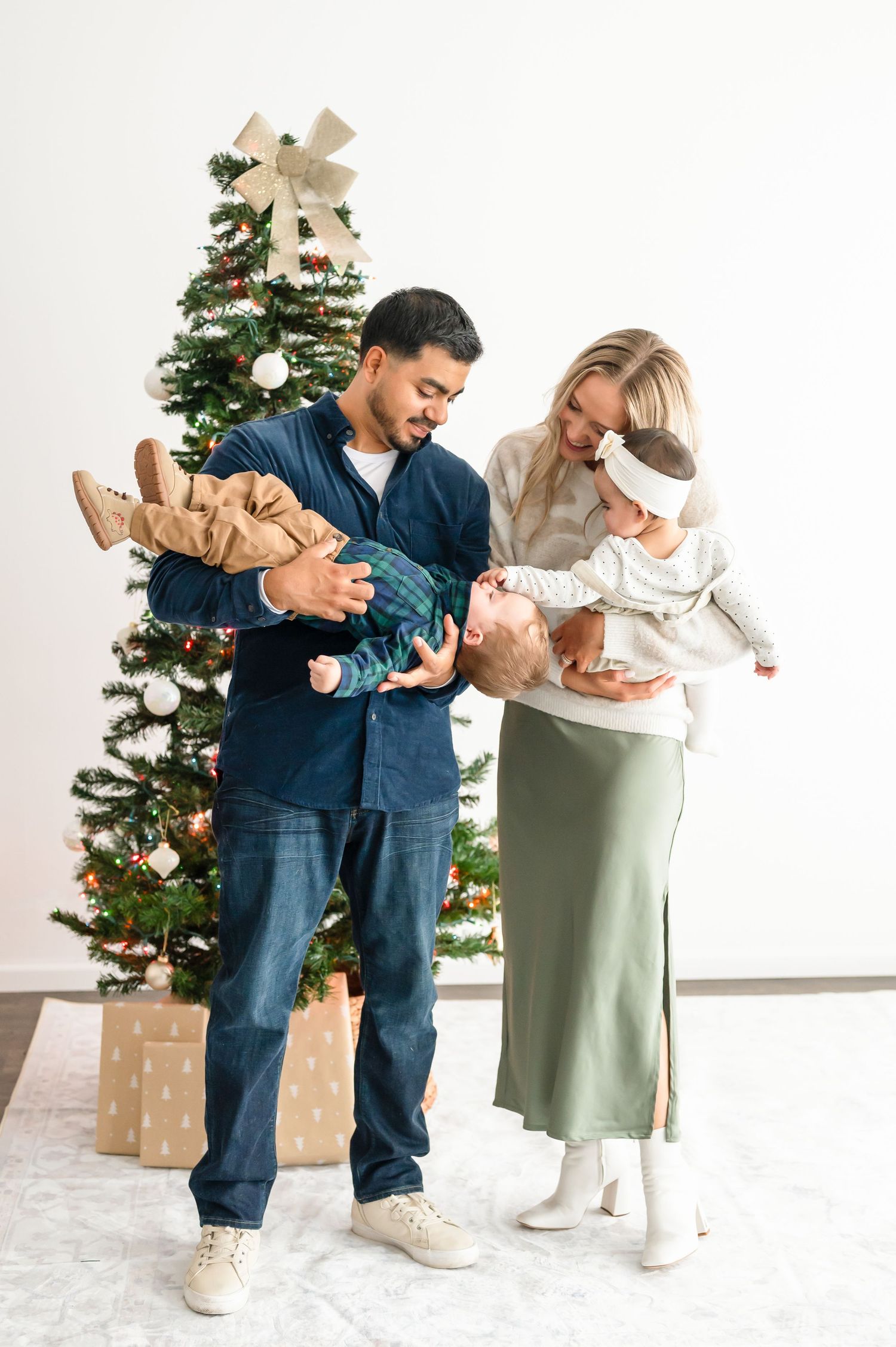 Family with twin toddlers in a candid moment with holiday decor and set up.