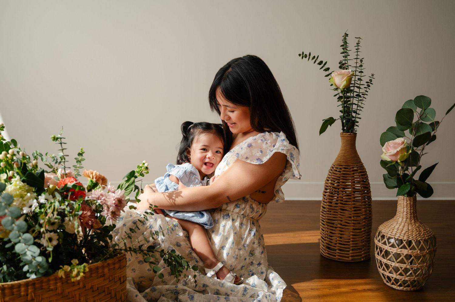 A tender moment between parent and child surrounded by floral arrangements and home decor.