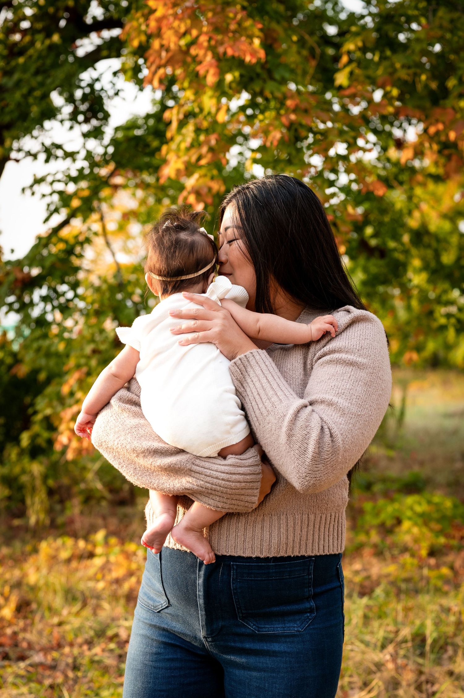 Autumn outdoor family photoshoot with warm sweaters and golden foliage.