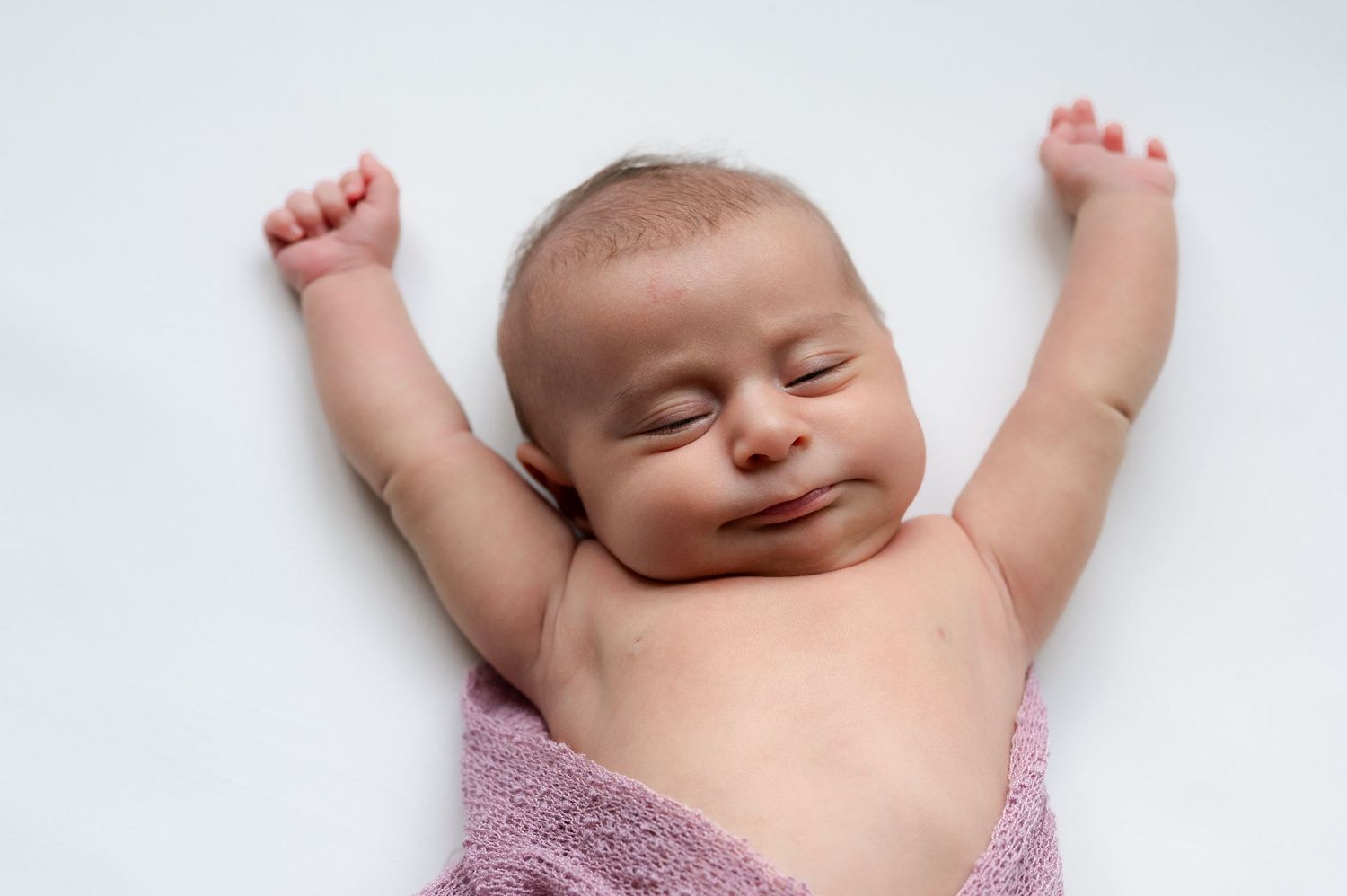 Newborn sleeping and stretching her arms