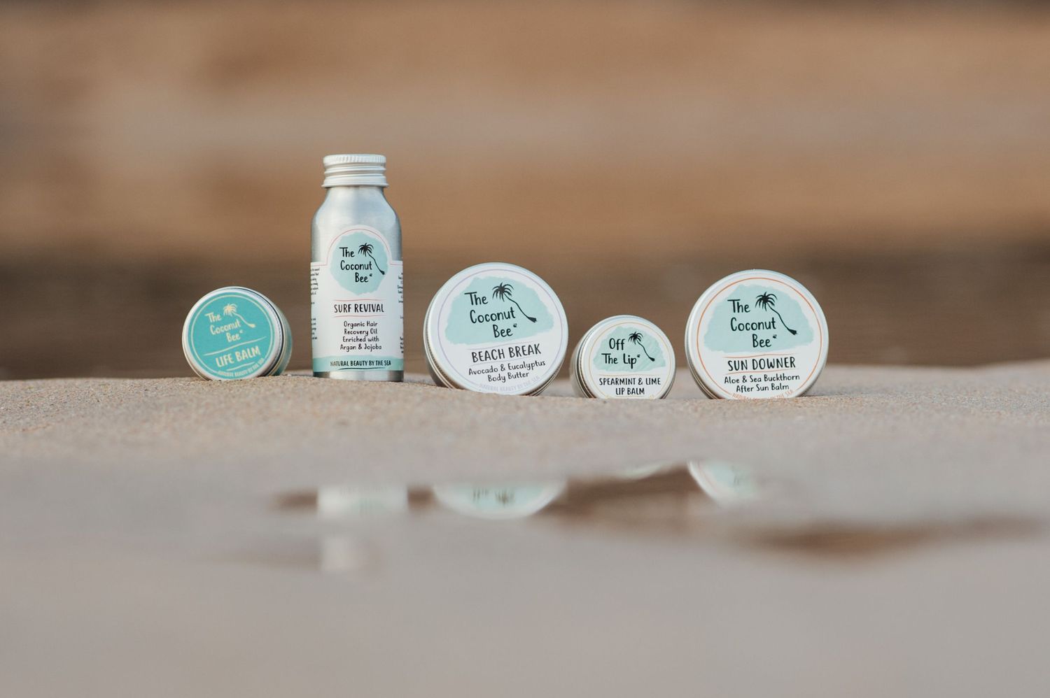 Collection of skincare products with mint green labels arranged on a wooden surface.