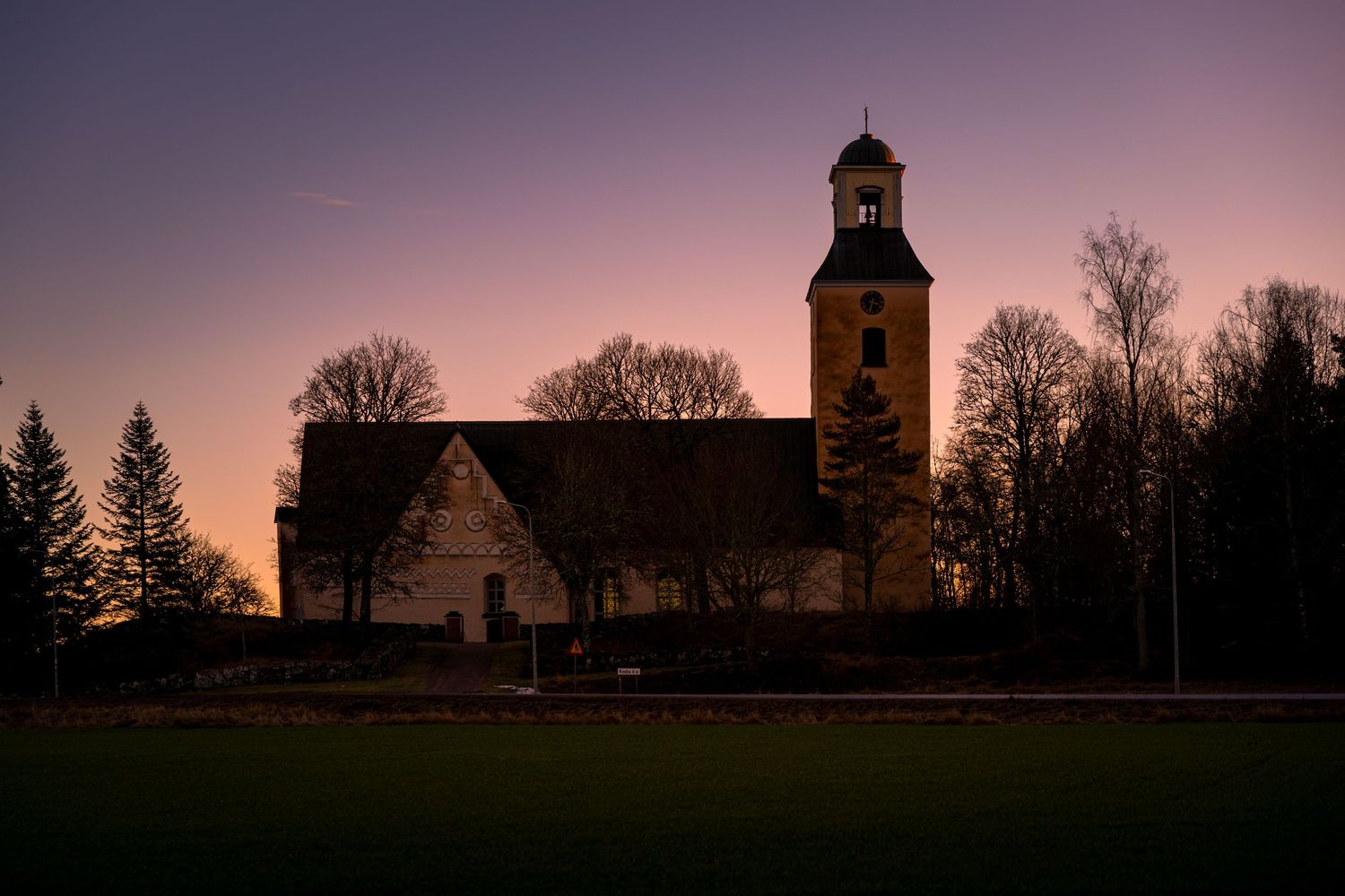 Four scenic silhouettes of churches against a dusky purple and orange sunset sky create a dramatic panoramic view.
