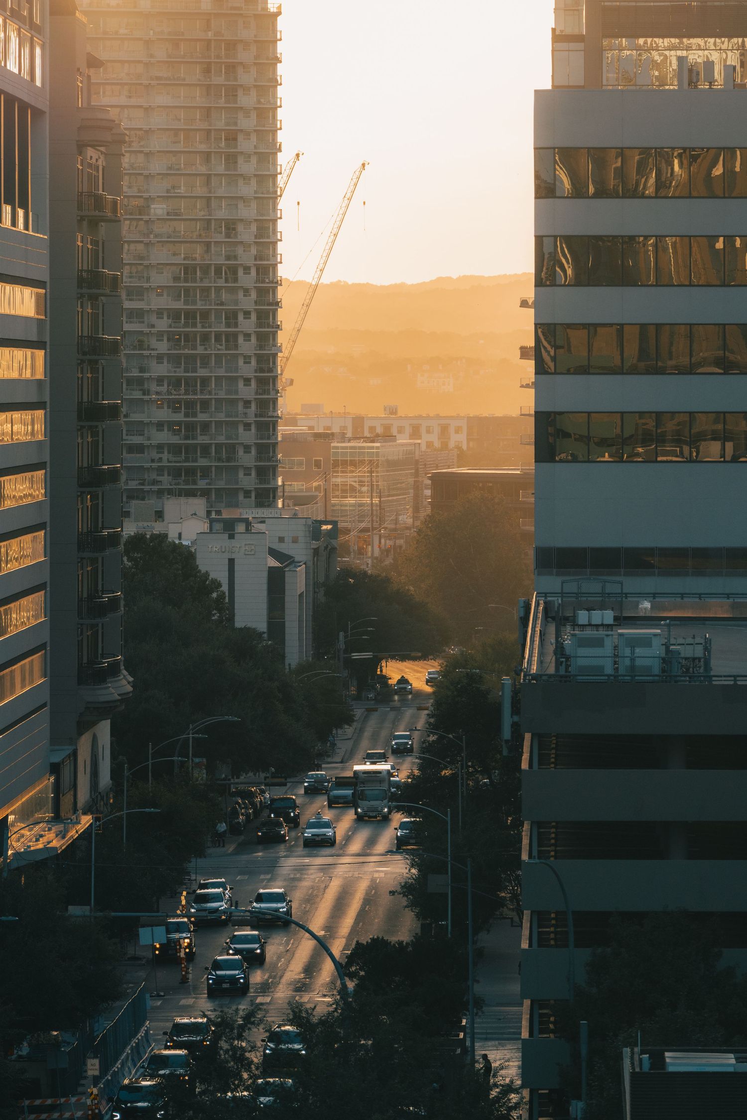 Downtown Austin city street framed by high-rise buildings in warm sunset light