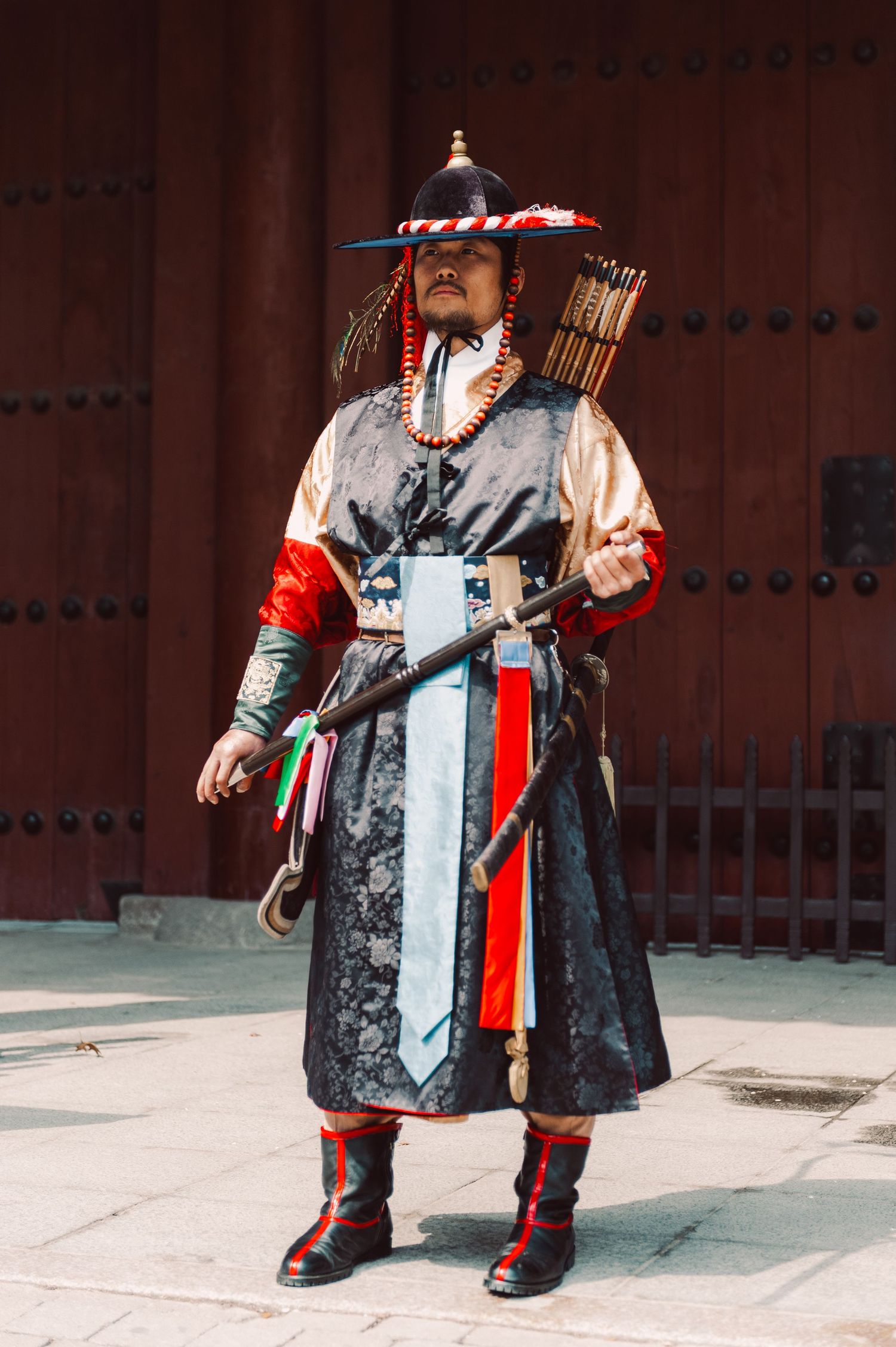 Traditional Korean royal palace guard wearing a colorful ceremonial uniform and holding a polearm in Seoul, South Korea.