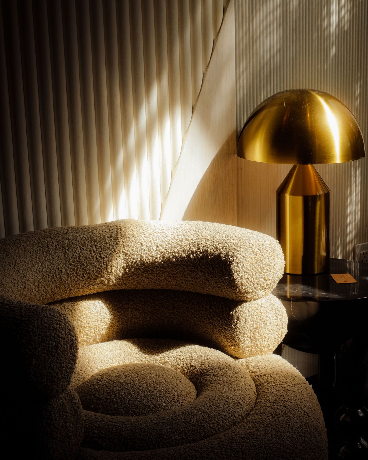 Warm sunlight illuminating a sculptural chair and brass lamp inside the Sofitel hotel in Beverly Hills, California