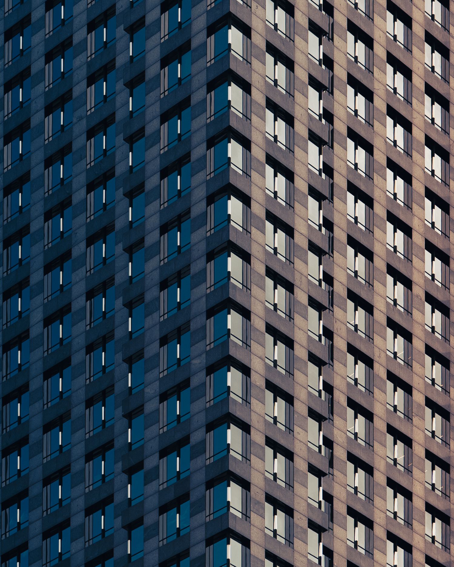 Geometric pattern of windows and shadows across a high-rise facade in downtown Chicago