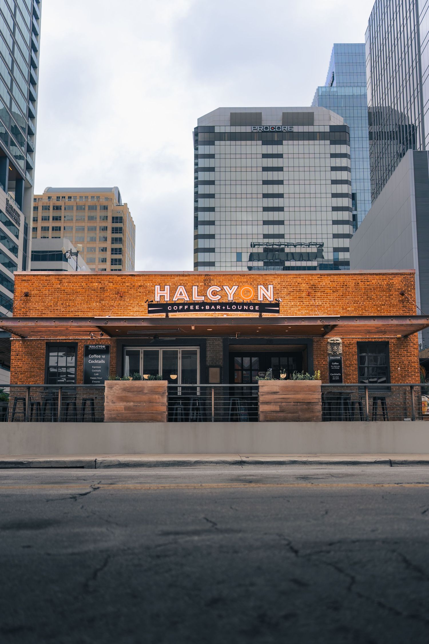 Exterior of Halcyon Coffee, Bar & Lounge surrounded by downtown Austin architecture