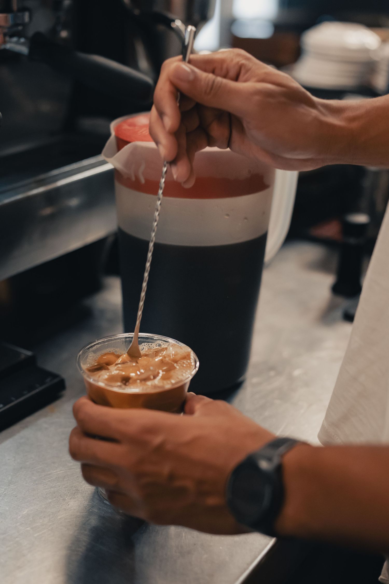 Barista preparing an iced coffee drink at Halcyon Coffee, Bar & Lounge in downtown Austin