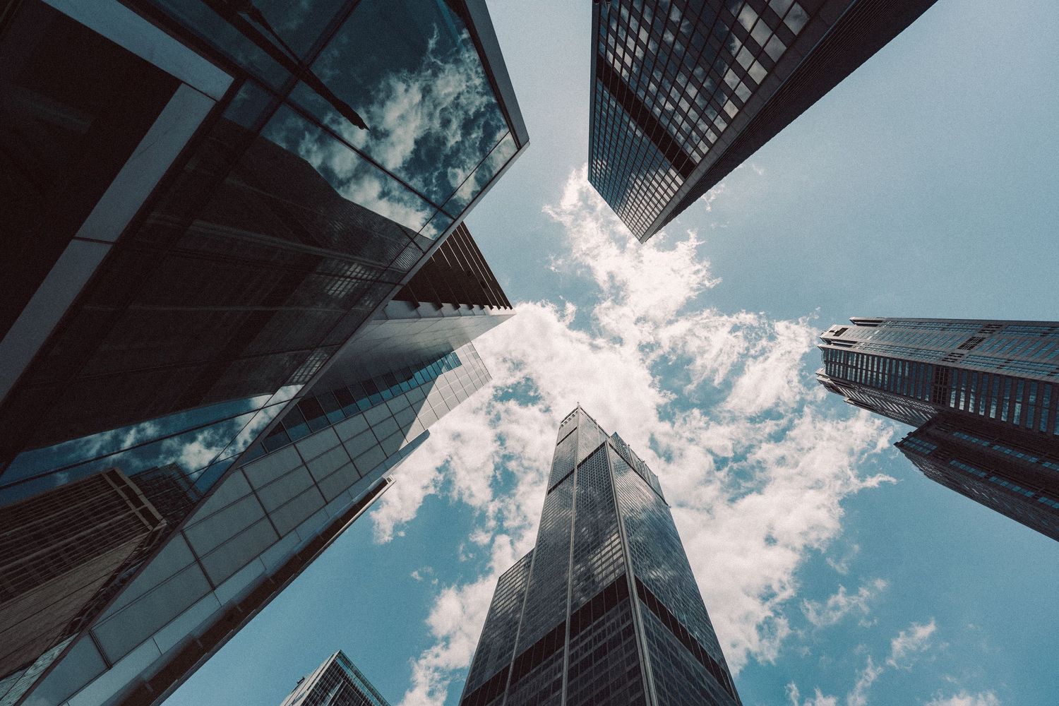 Looking upward between skyscrapers toward the sky in downtown Chicago