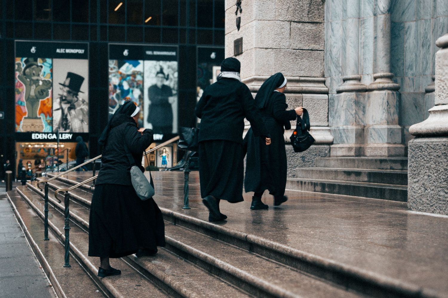Three sisters walking up stone steps of St Patrick's Cathedral in Manhattan, New York City