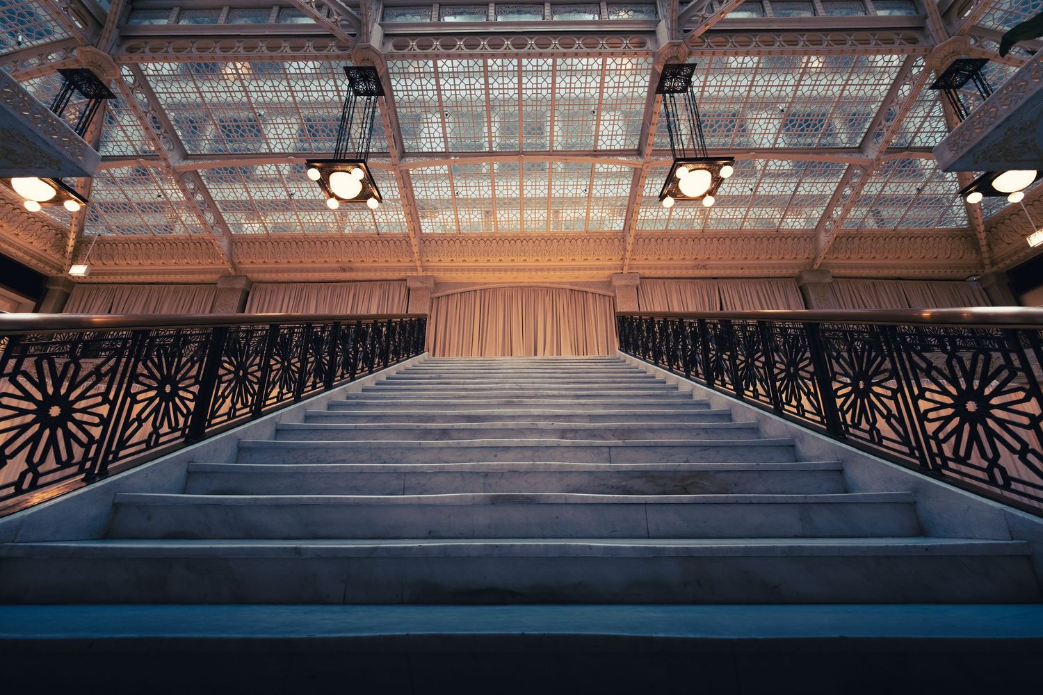 Ornate staircase beneath the glass atrium inside the historic Rookery Building in Chicago