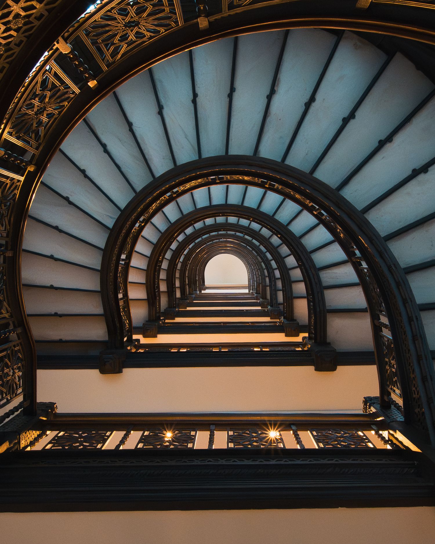 Looking upward through repeating arches and ornate metalwork inside the Rookery Building in Chicago