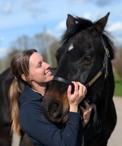 Osteopat Linnea Stray kelar med en mörk häst