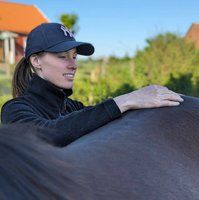 Osteopat Linnea Stray känner igenom en mörk häst
