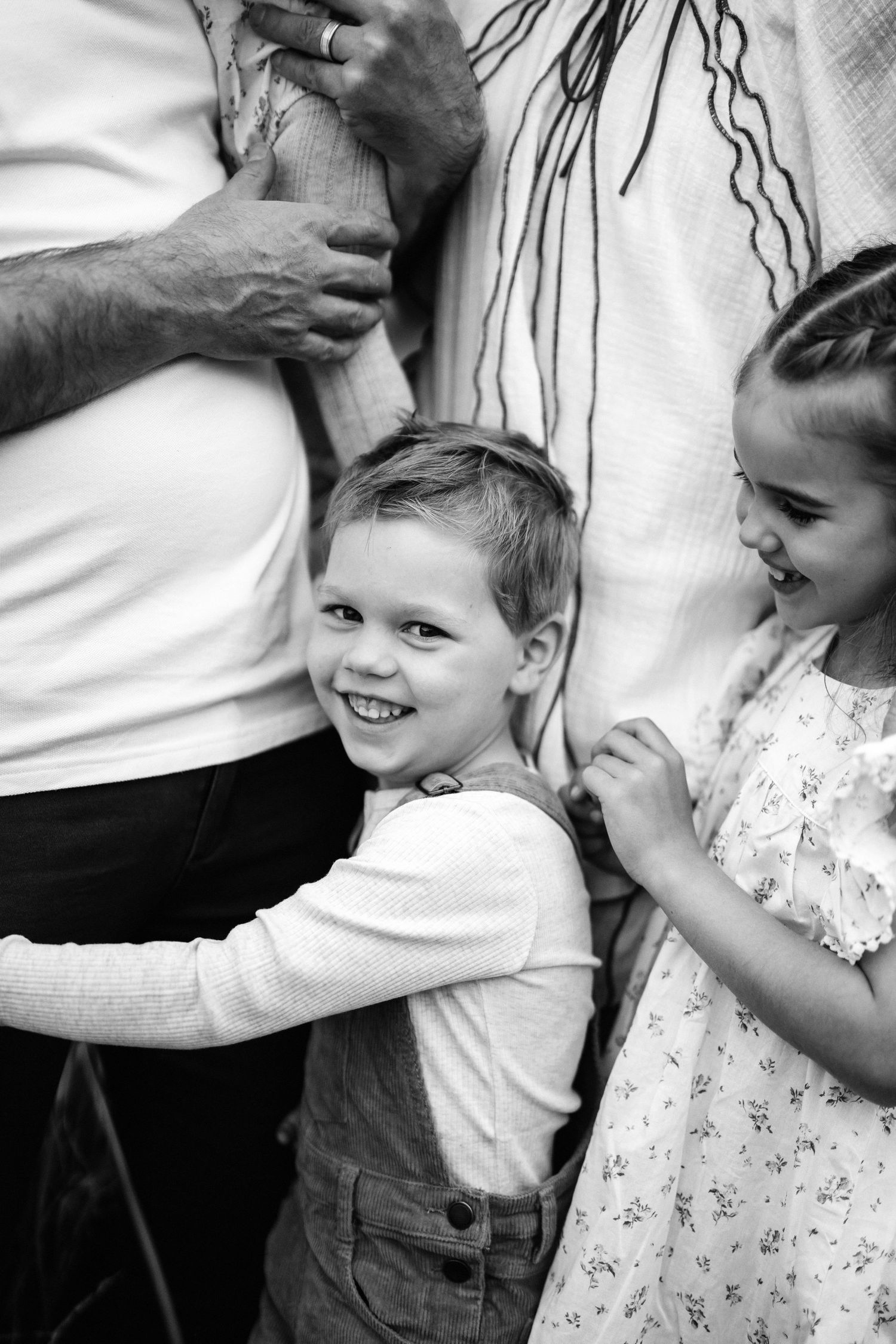 Black and white candid photo of young children with their parents during a Christchurch family photography session